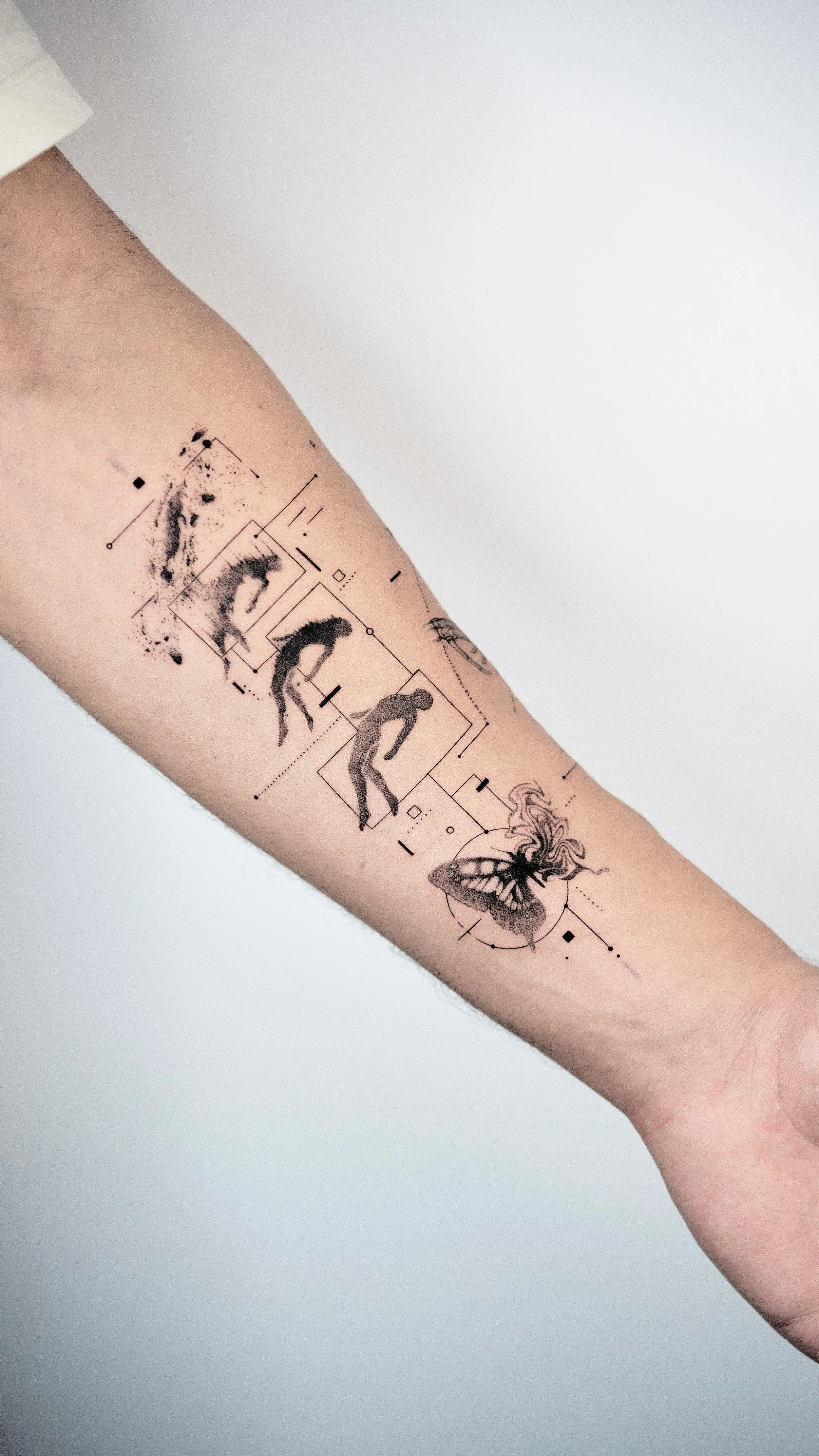 Tattoo of a series of evolving human figures and a butterfly with abstract geometric elements on a person's forearm.