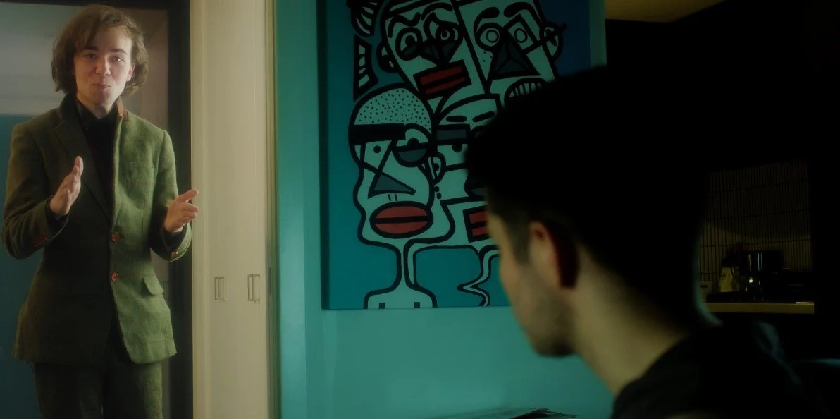 Two people in a room with modern abstract art on the wall.