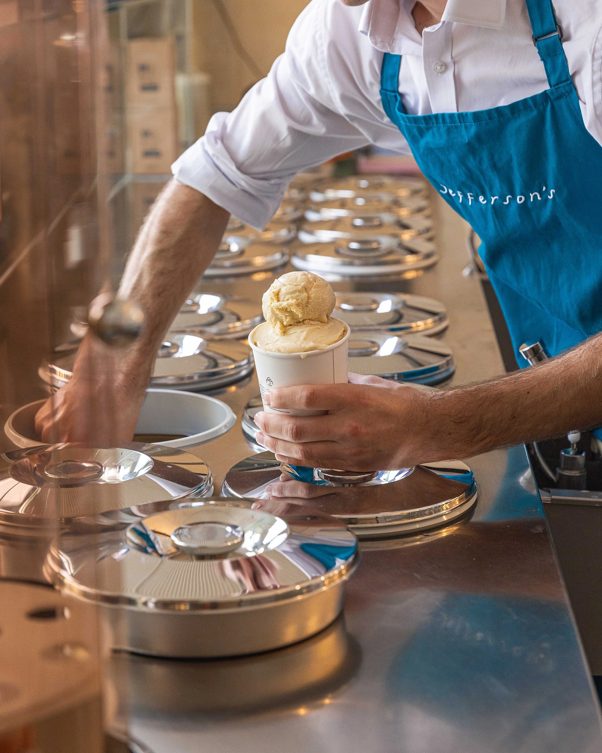 Team member scooping artisanal ice cream from pozzetti