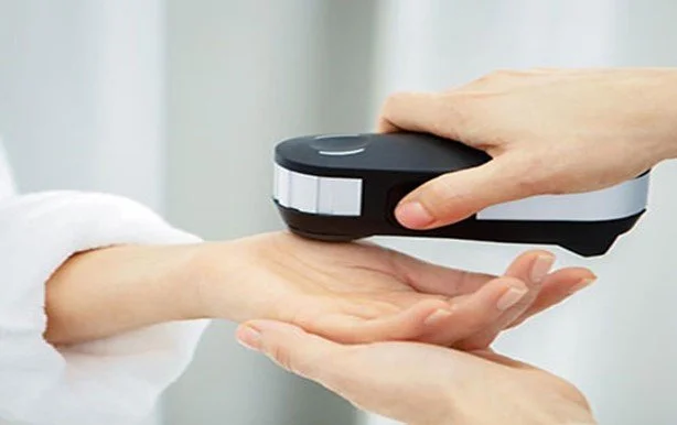 A person being checked with a handheld metal detector by another person, likely at security.