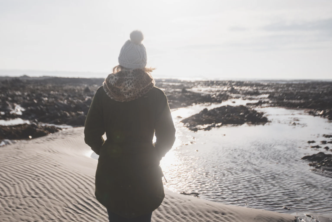 woman standing on beach in winter