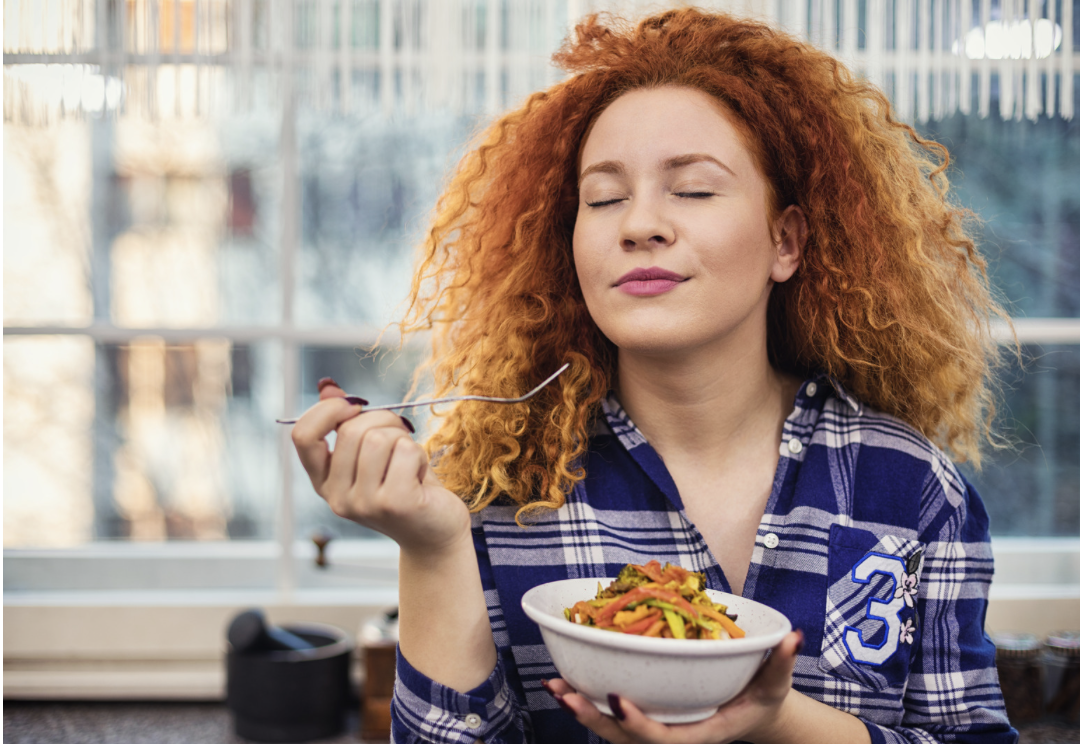 Woman eating colorful bowl of food