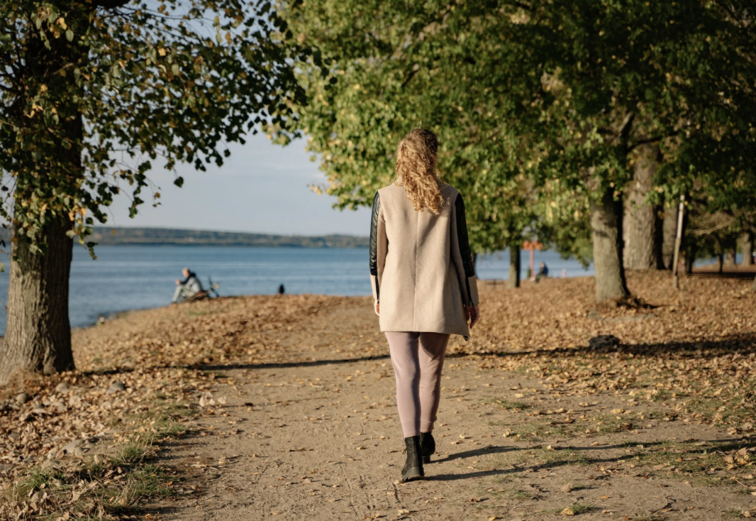 Woman walking on path near water