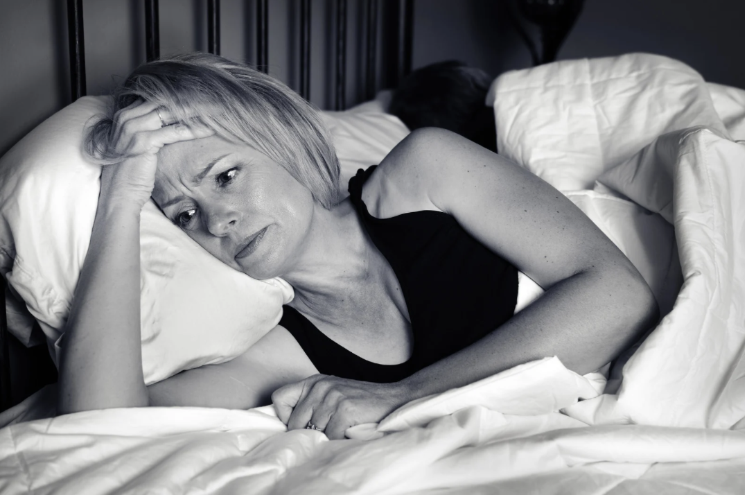 woman lying on side awake in bed