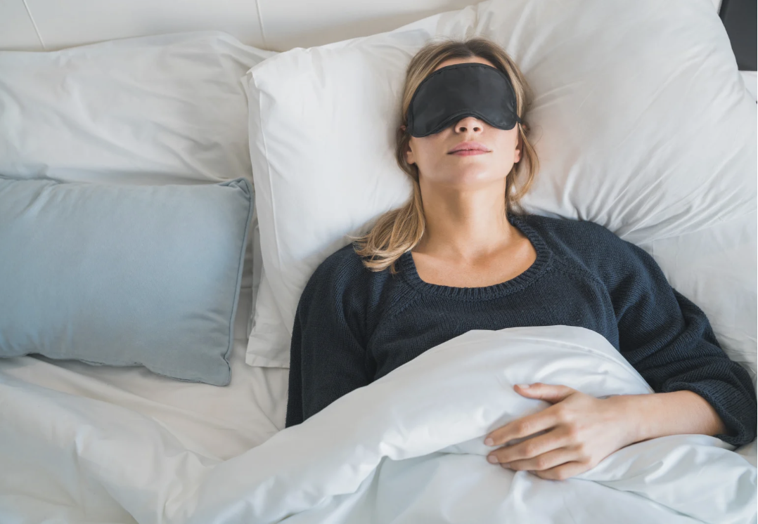 woman wearing sleeping mask in bed