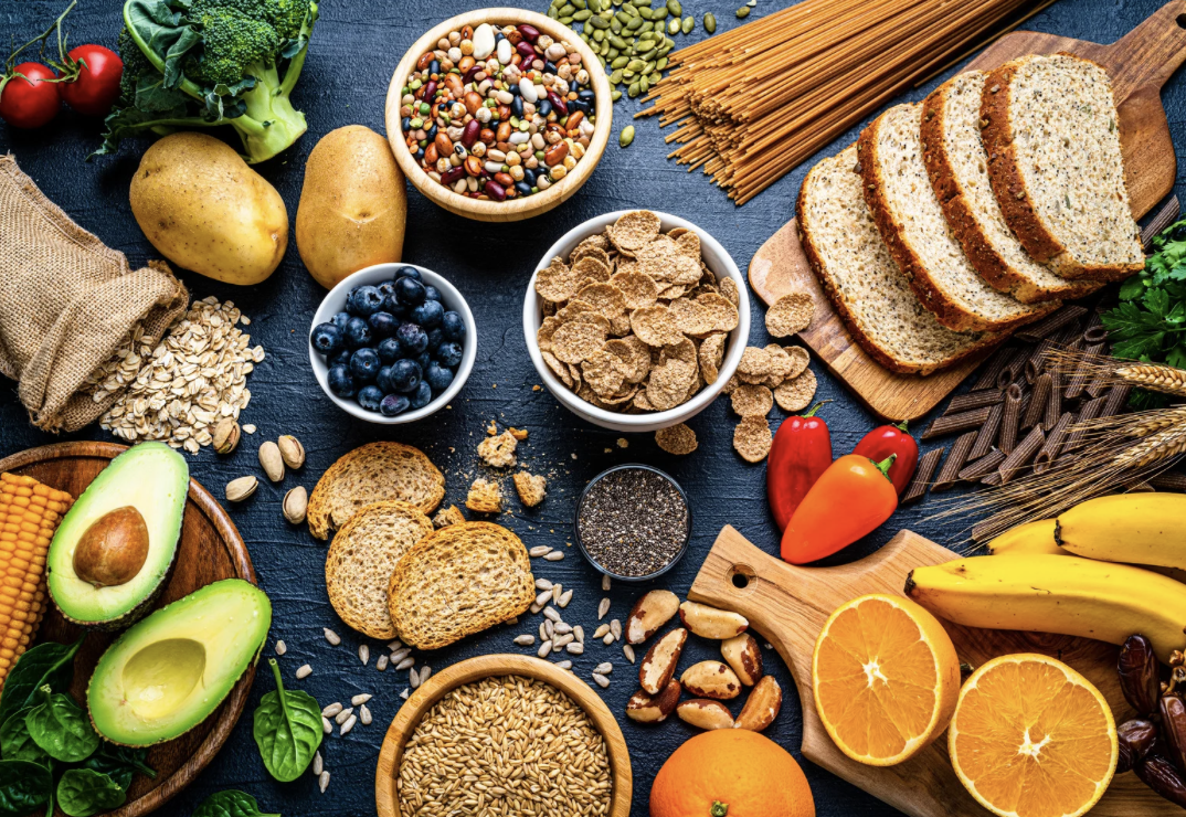 Photo of various fiber-rich foods such as berries, breads, avocados