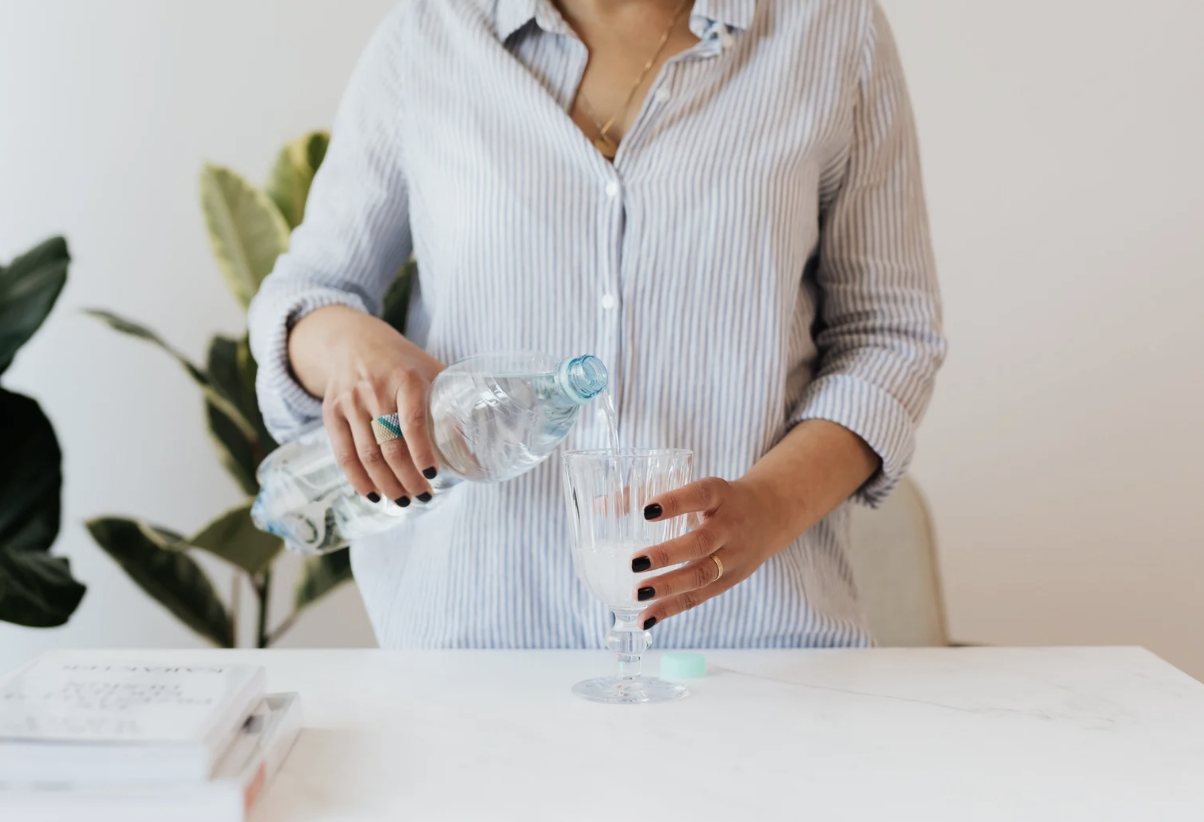 Woman pouring water from water bottle