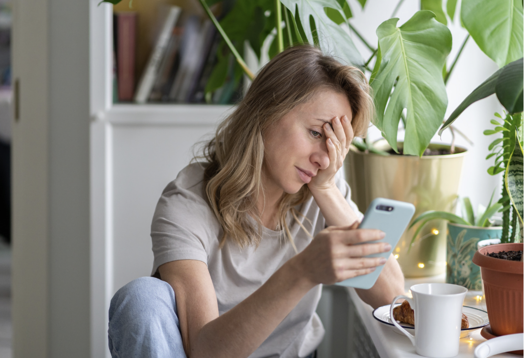 woman looking at phone with confused expression