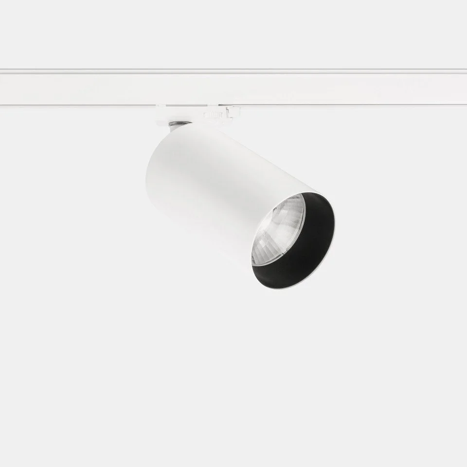 White ceiling spotlight with black interior, mounted on ceiling track.