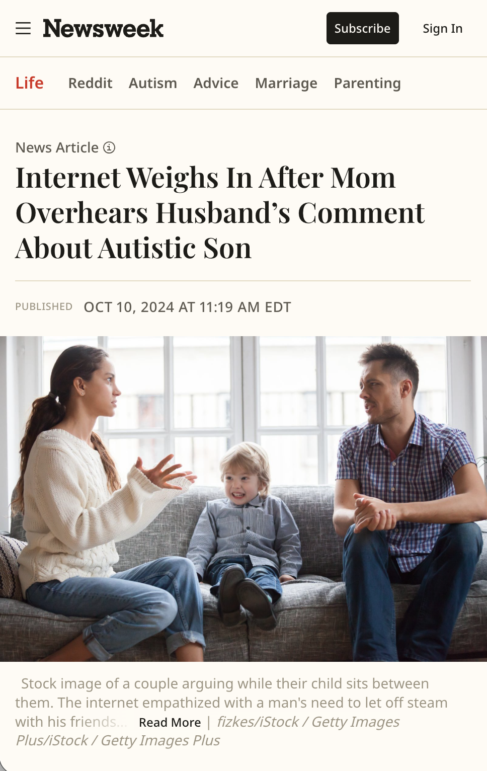 A stock photo of a couple arguing while their child sits between them on a couch.