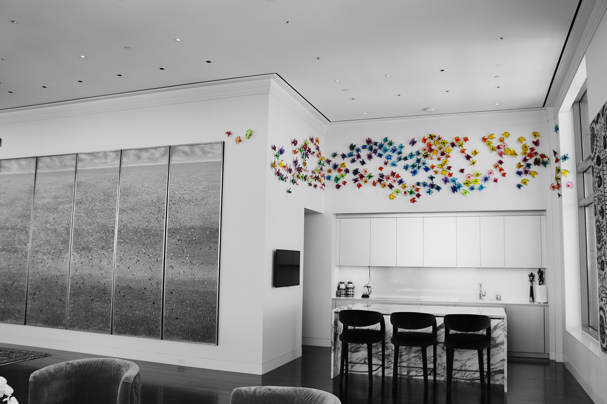 Modern living room with black and white color scheme and colorful butterfly wall art.