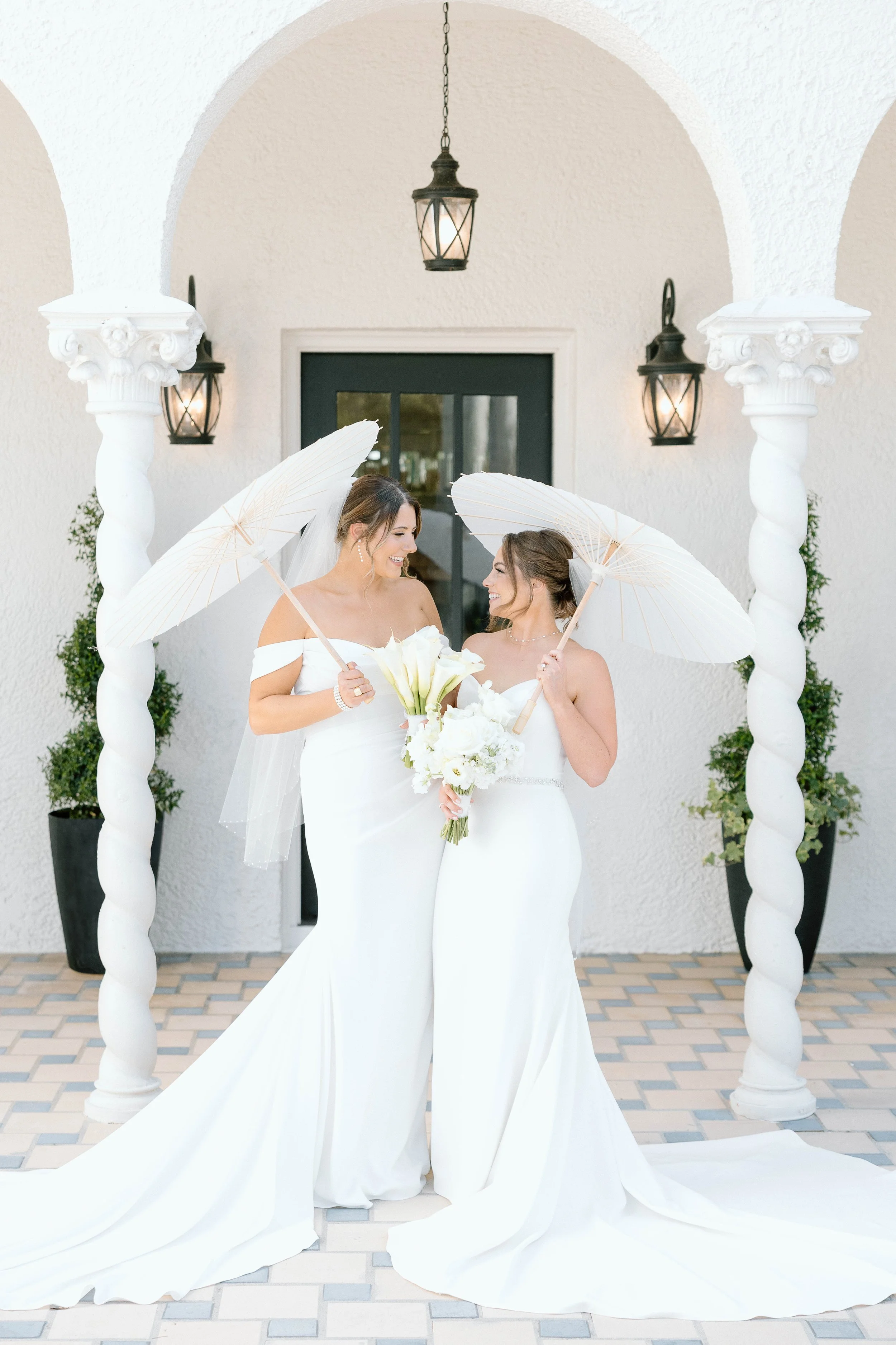 Bride and bride holding parasols in front of the Alderman House by Mizner by Fort Myers Wedding Photographer