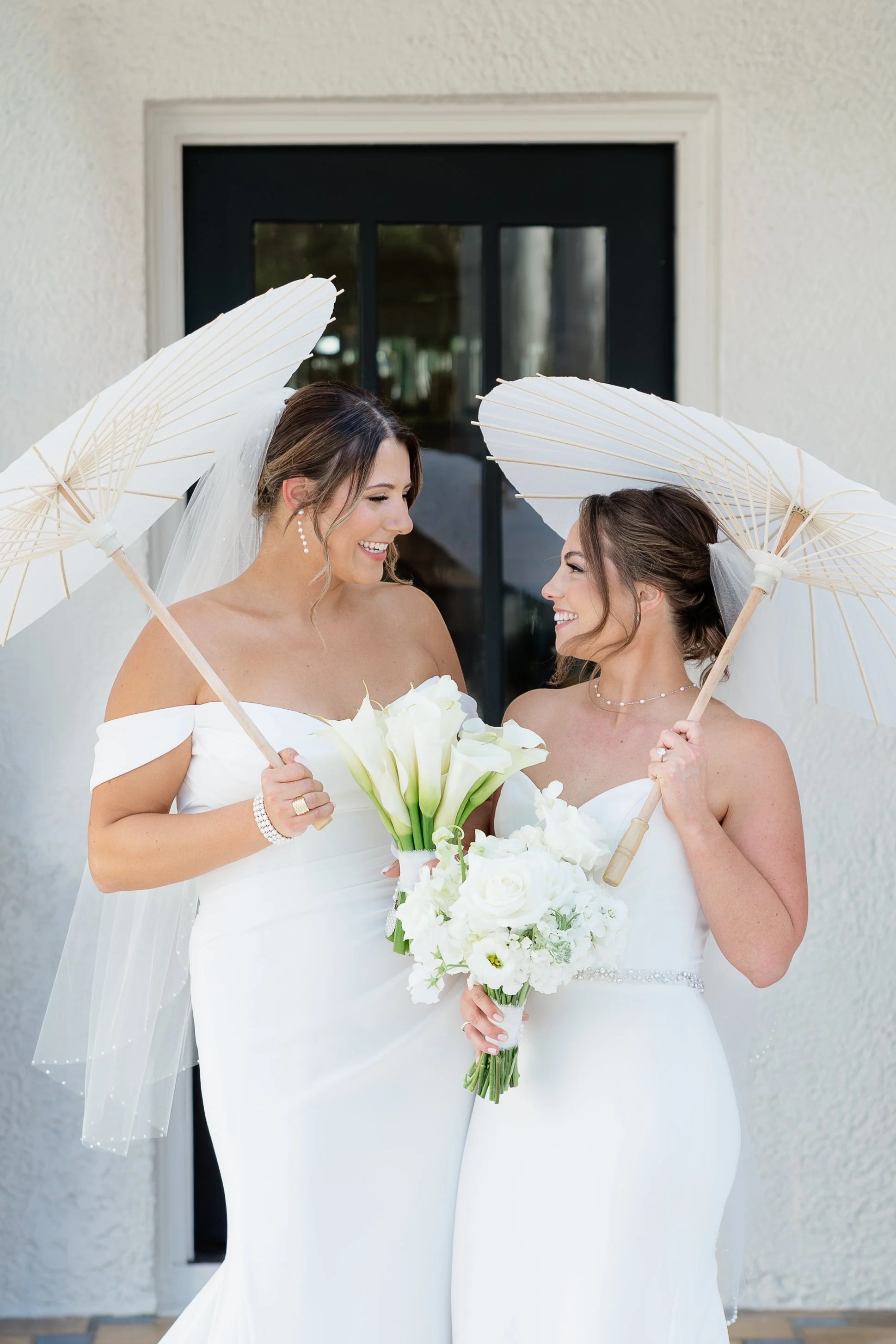 Two brides holding parasols at the Alderman House by Mizner by Fort Myers wedding photographer