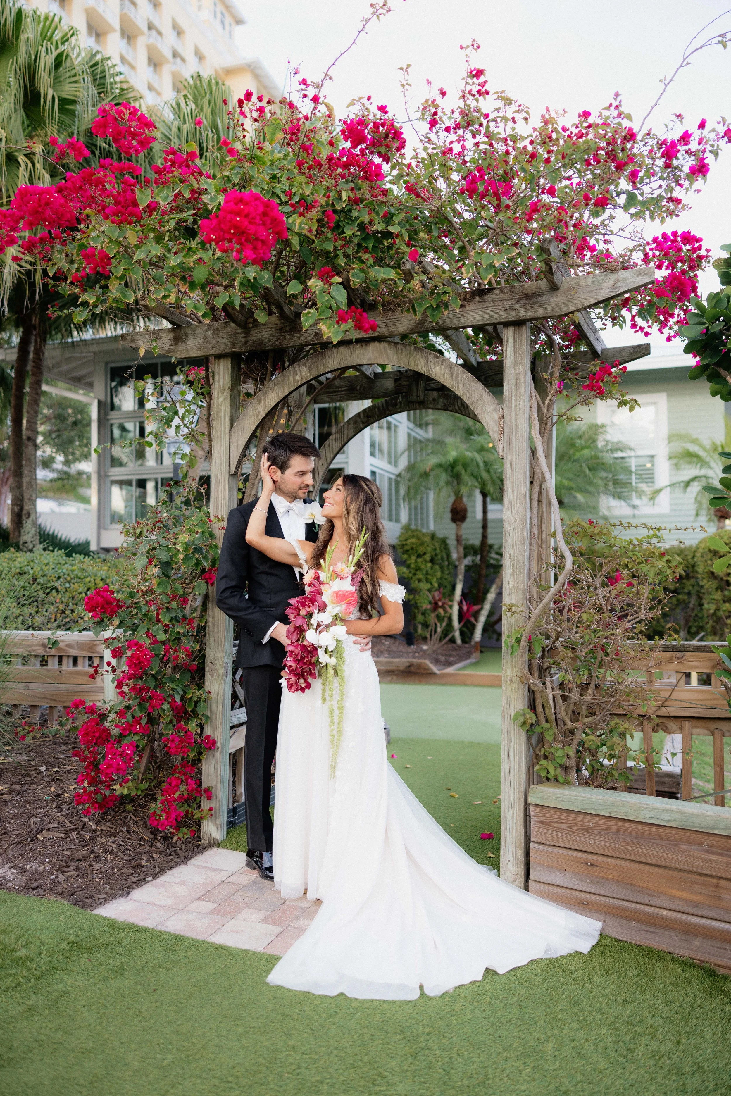 Bride and groom portrait under arch with flowers at the Hyatt Regency Coconut Point Resort and Spa by Naples Wedding Photographer