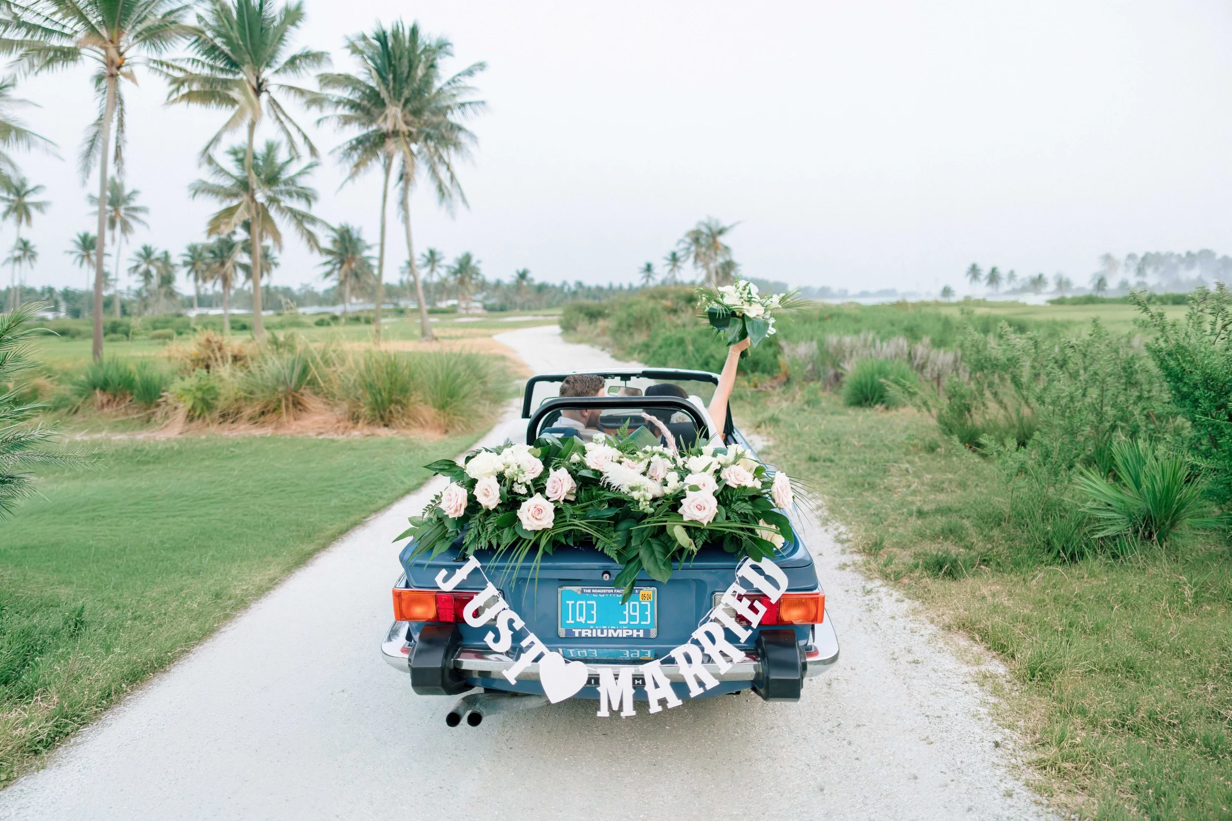 Photo of bride and groom in retro car by Naples Wedding Photographer