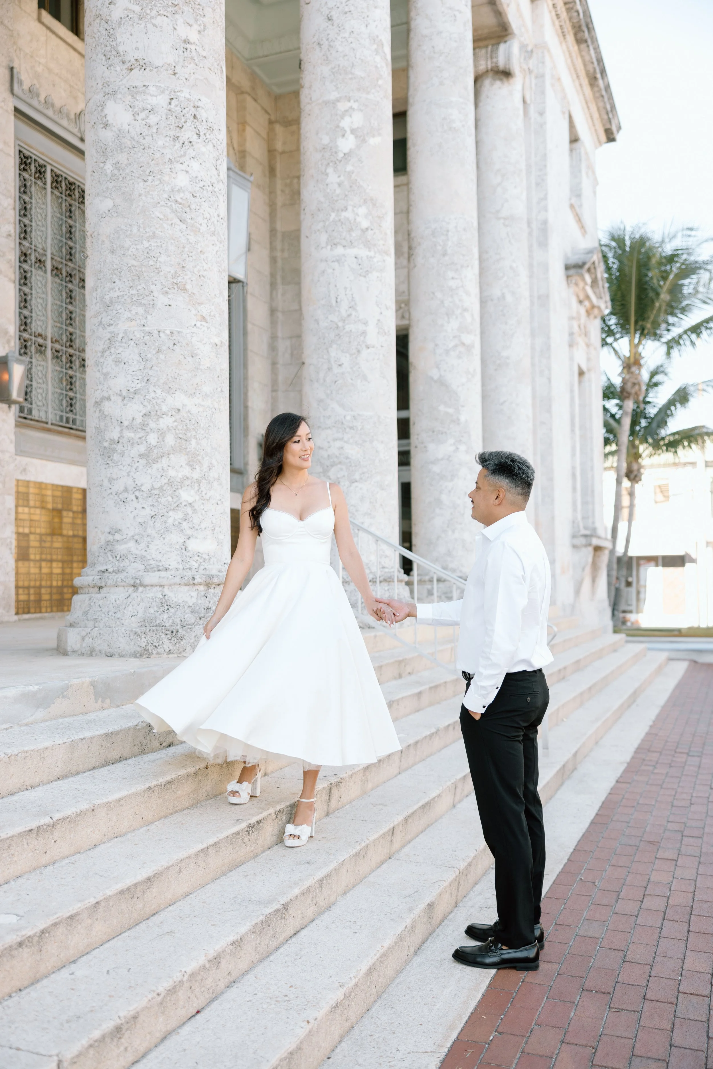 Girl wearing a white dress for her engagement session at the Sydney and Berne Davis Art Center in Downtown Fort Myers, Florida