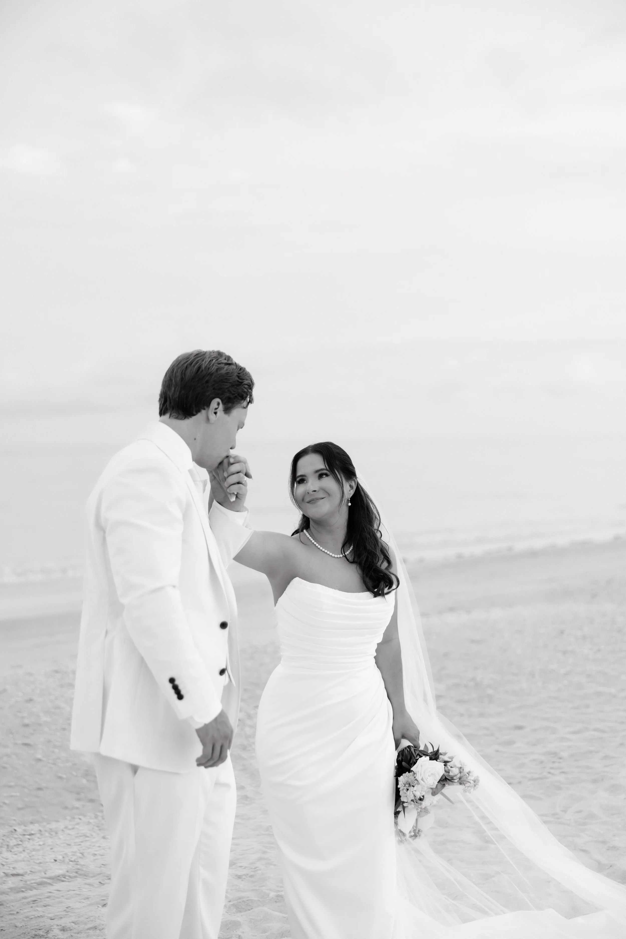 Groom kisses brides hand - beach wedding at Sundial Resort by Sanibel Wedding Photographer