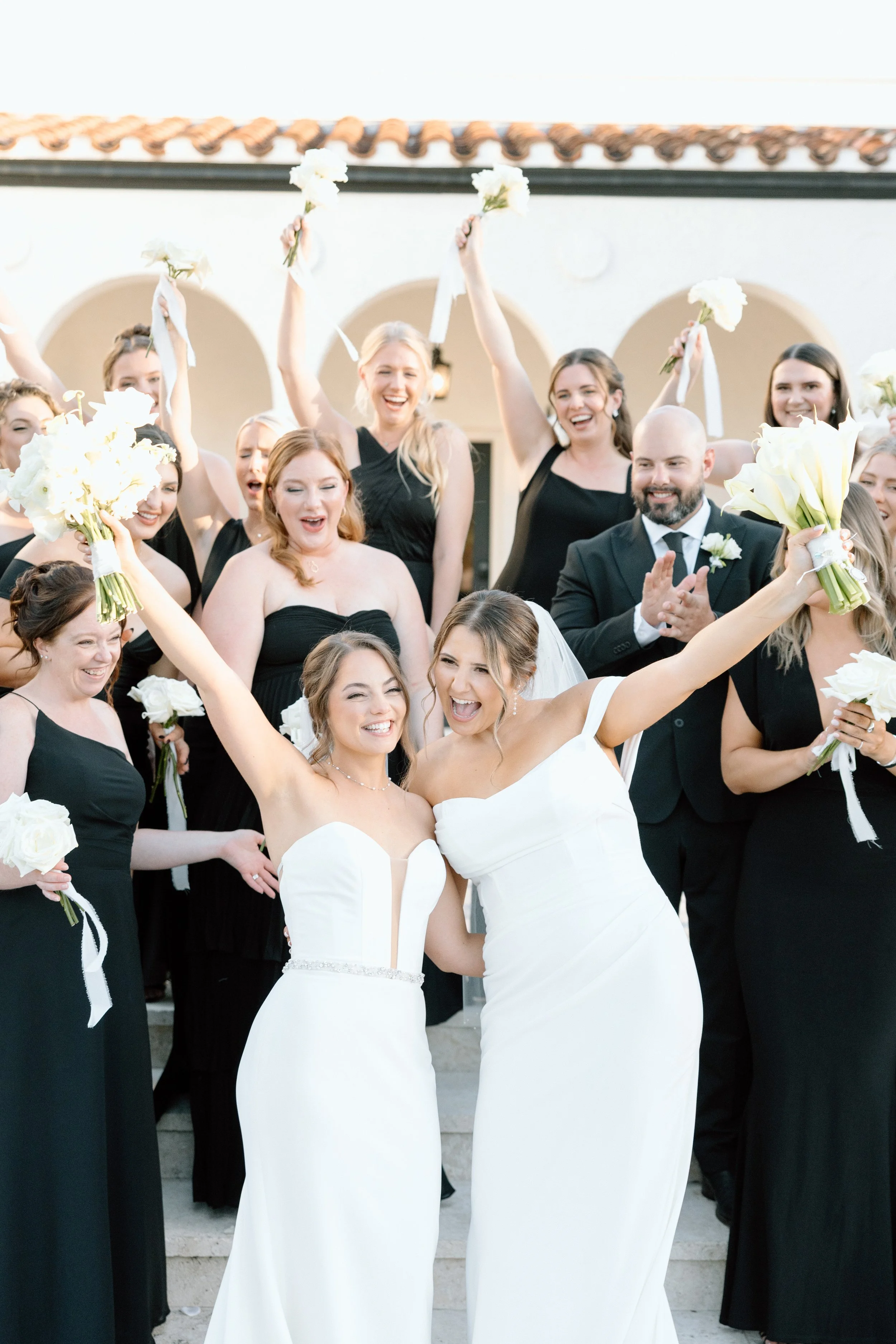 Brides cheering with bouquets at the Alderman House by Mizner by Fort Myers wedding photographer