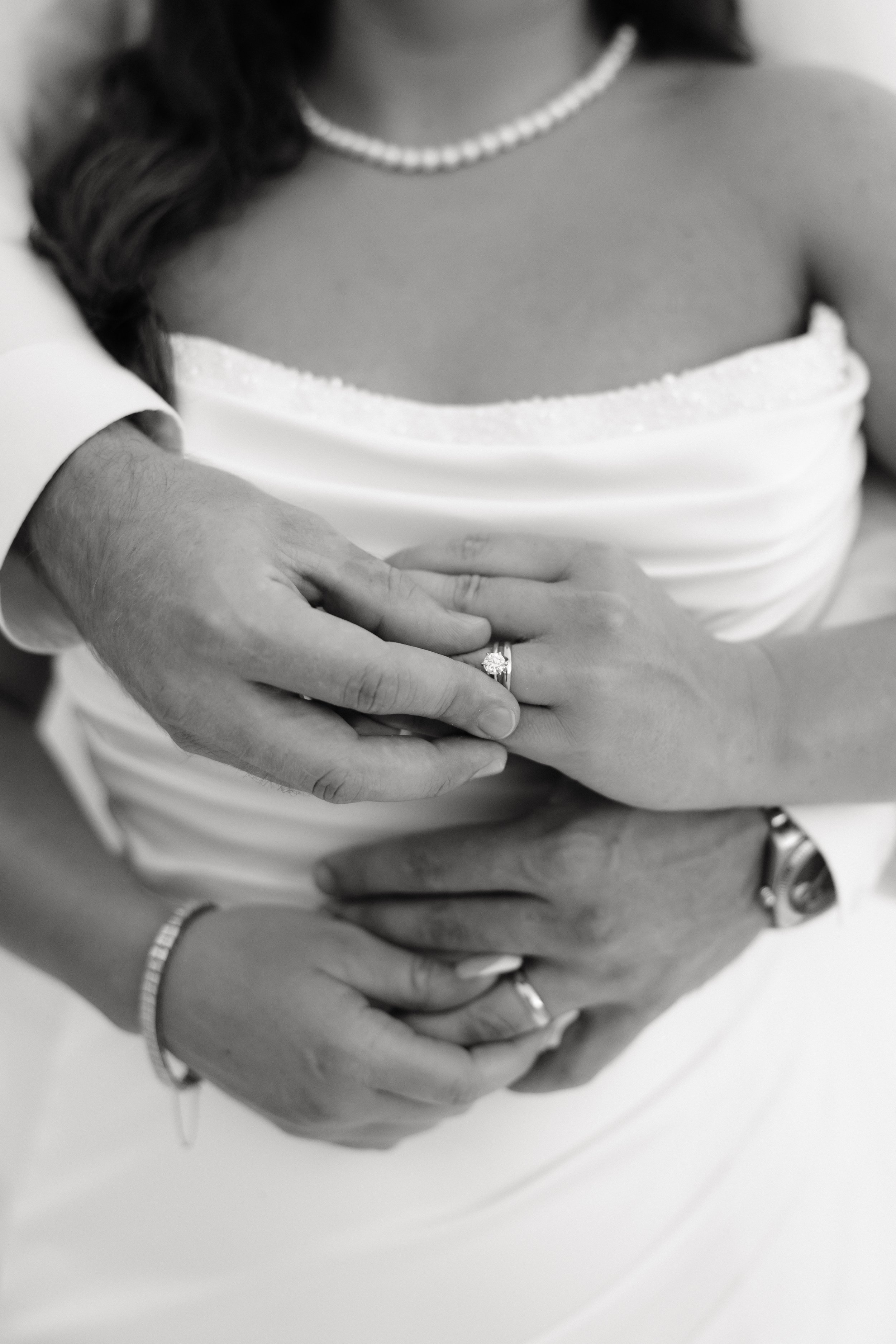 Black and white photo of bride and grooms rings