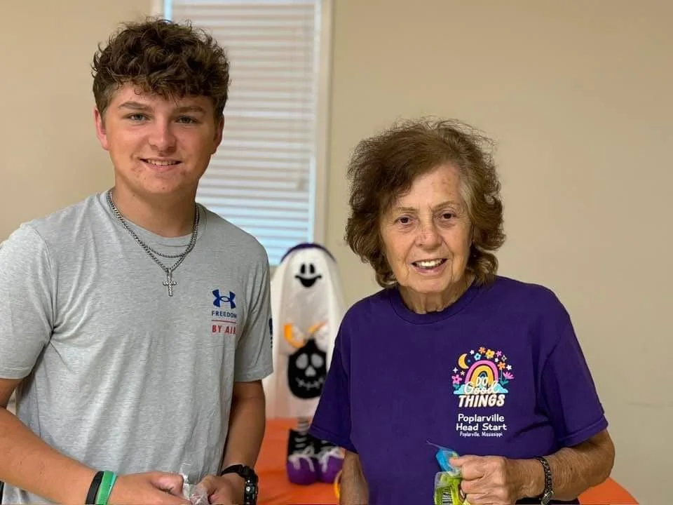 Image of two church members. On the left is a member of the youth group and on the right of the young man, is an older female adult church member.