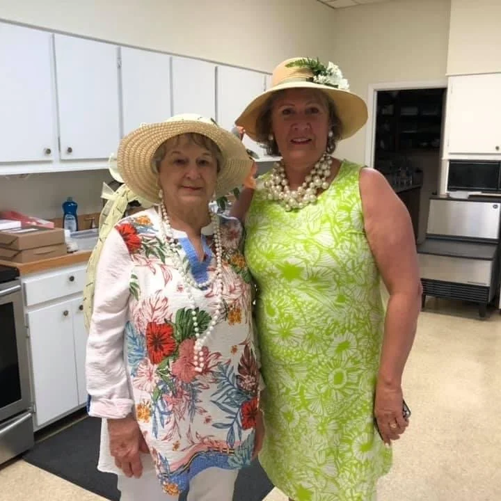 This is an image of two female church members with Easter hats on, smiling at the camera.