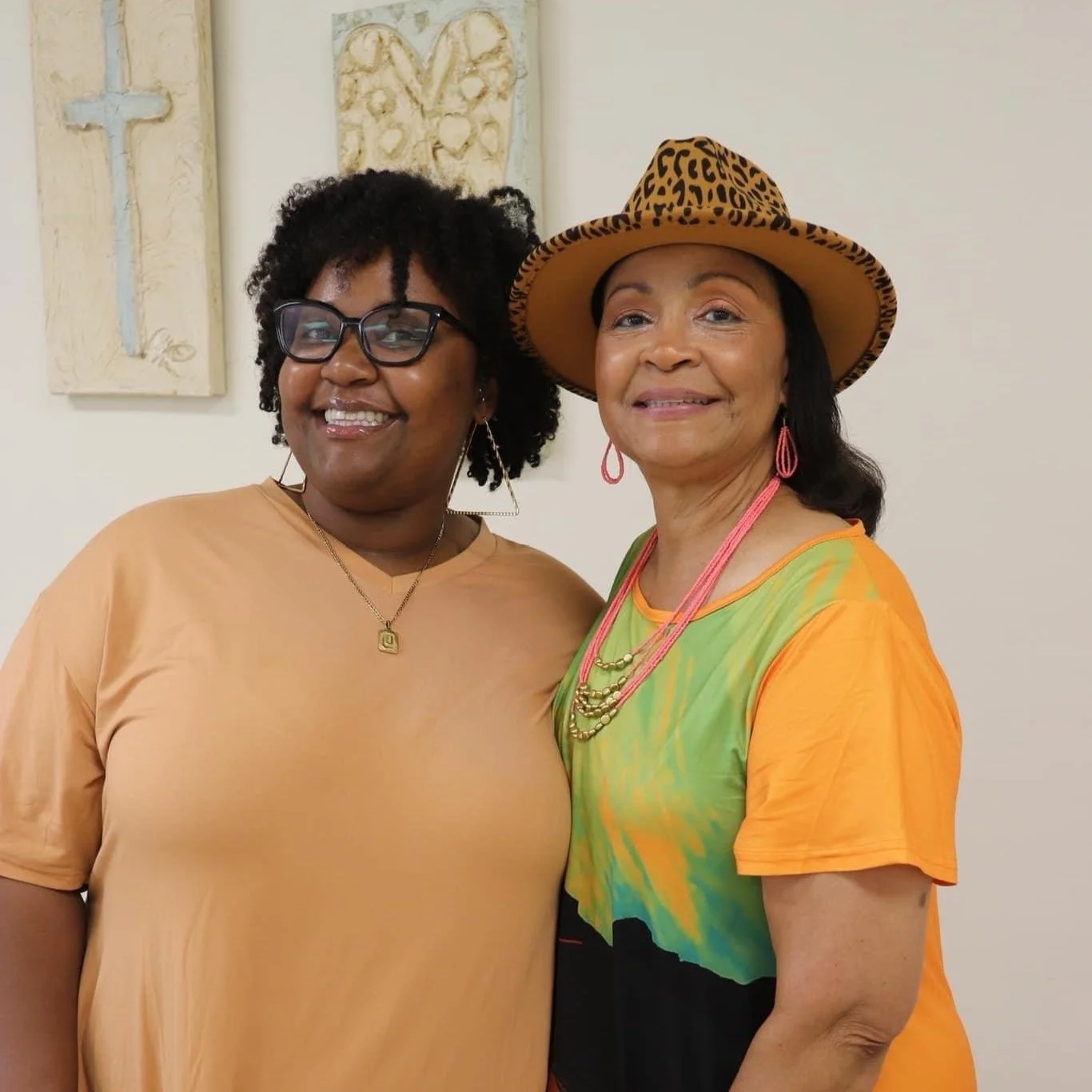 This is an image of two adult female church members. They are smiling and embracing.