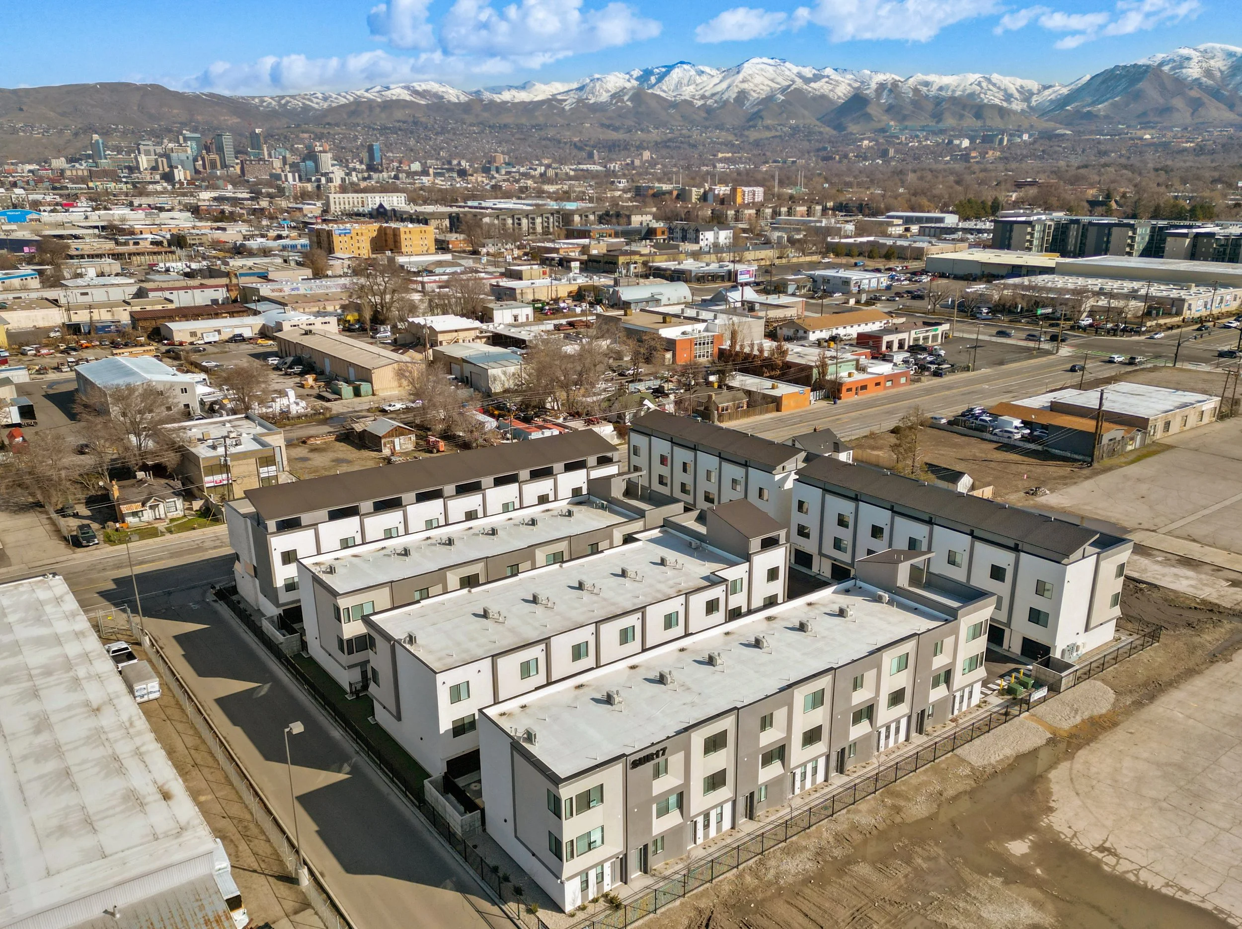 Aerial view of the SUR17 site plan, rows of three-story townhomes around drive courts, with downtown Salt Lake City and the mountains behind