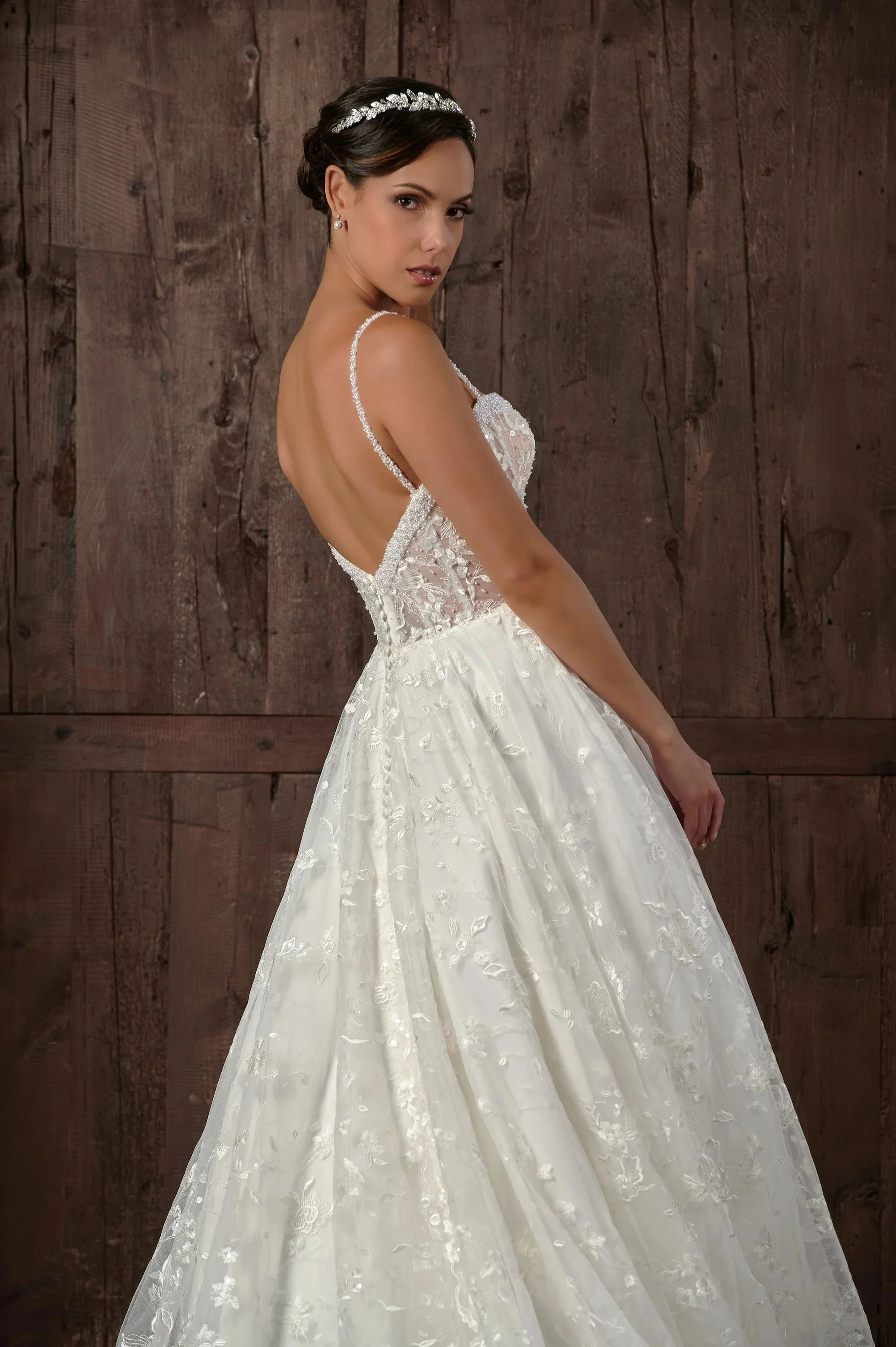 Detalle lateral de la espalda del vestido de novia Qasim, con tirantes de pedrería y falda de encaje floral.