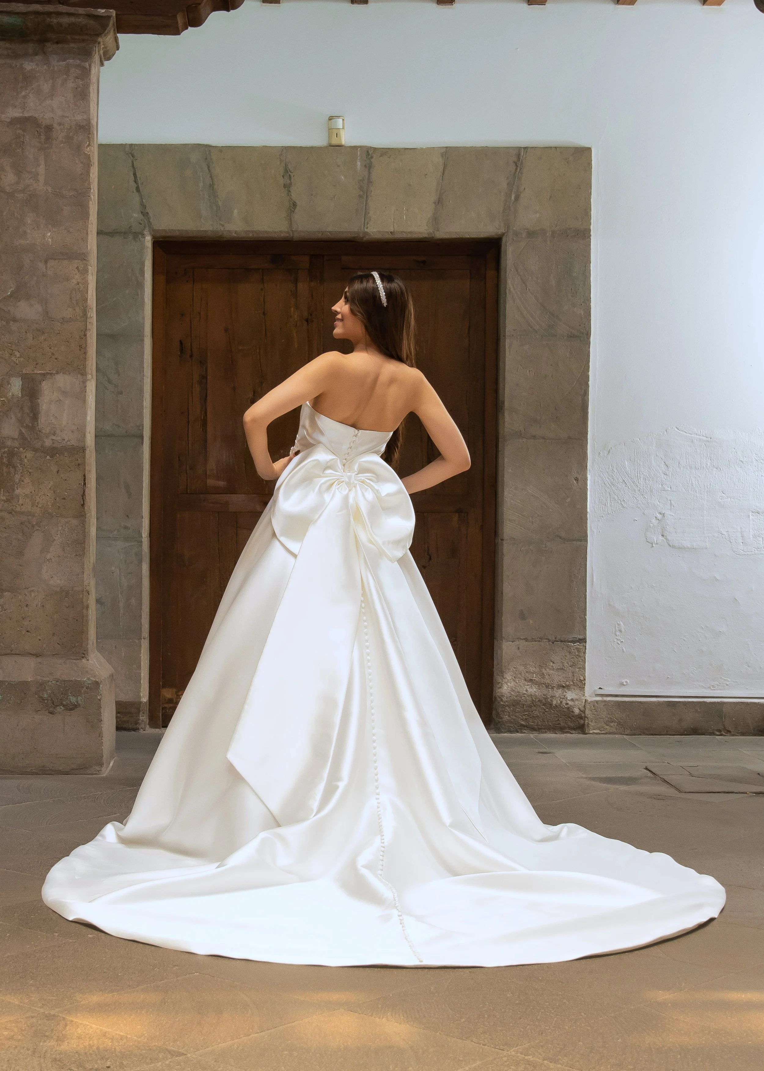 Espalda del vestido de novia Loretta con moño de satén y cola larga en línea A.