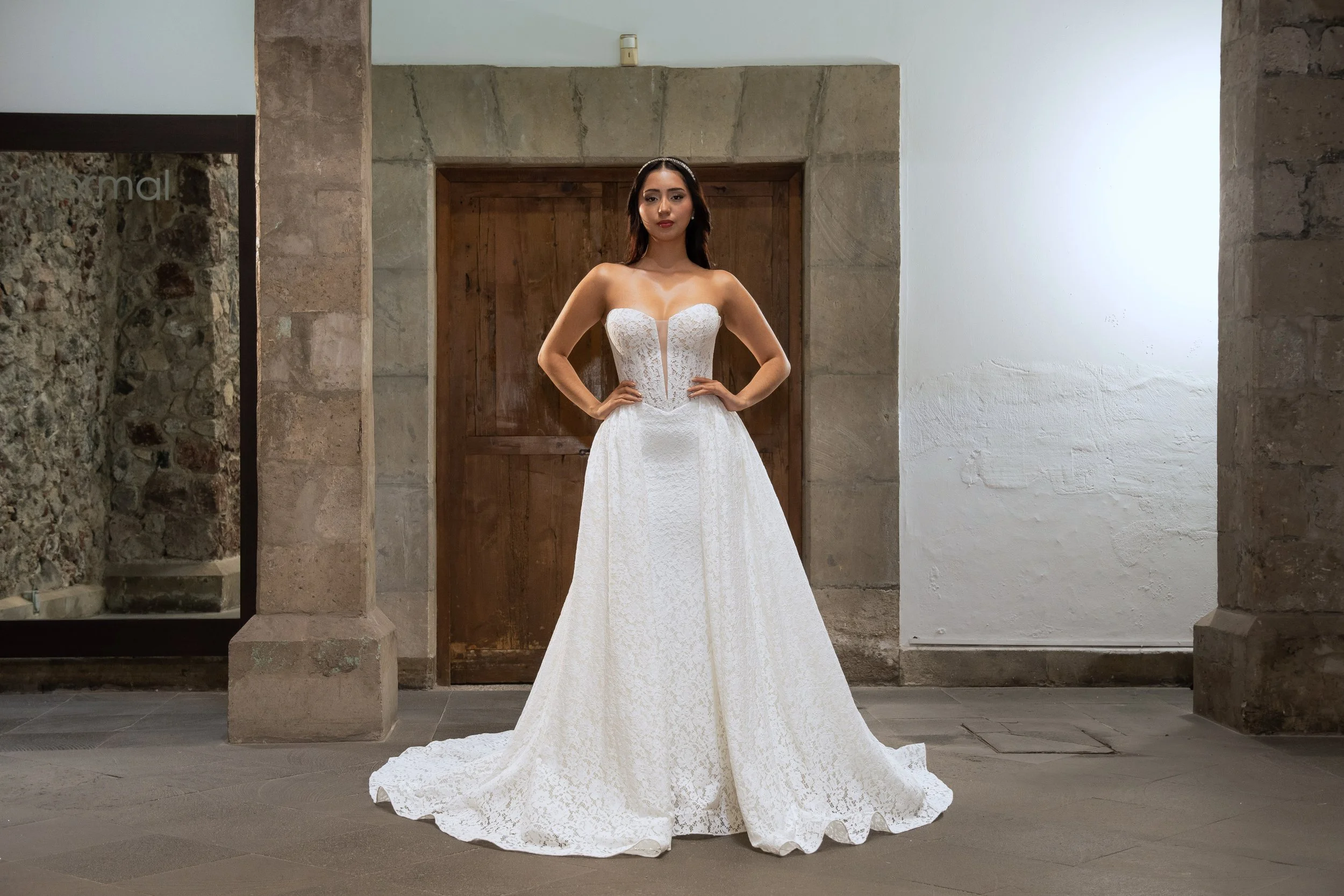 Vestido de novia Leah con la sobrefalda de encaje desmontable puesta, que añade volumen y una cola amplia, vista de frente.