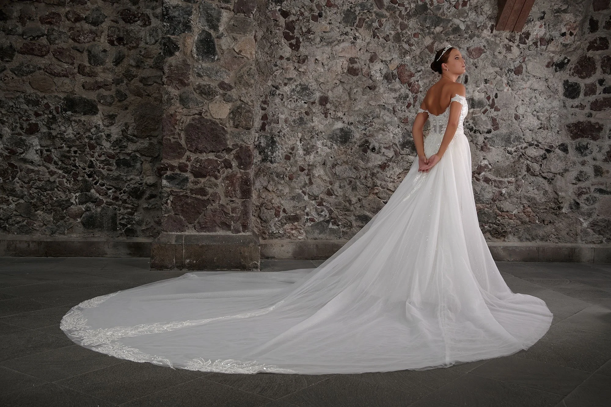 Espalda del vestido de novia Chantal con sobrefalda de tul brillante y cola larga.
