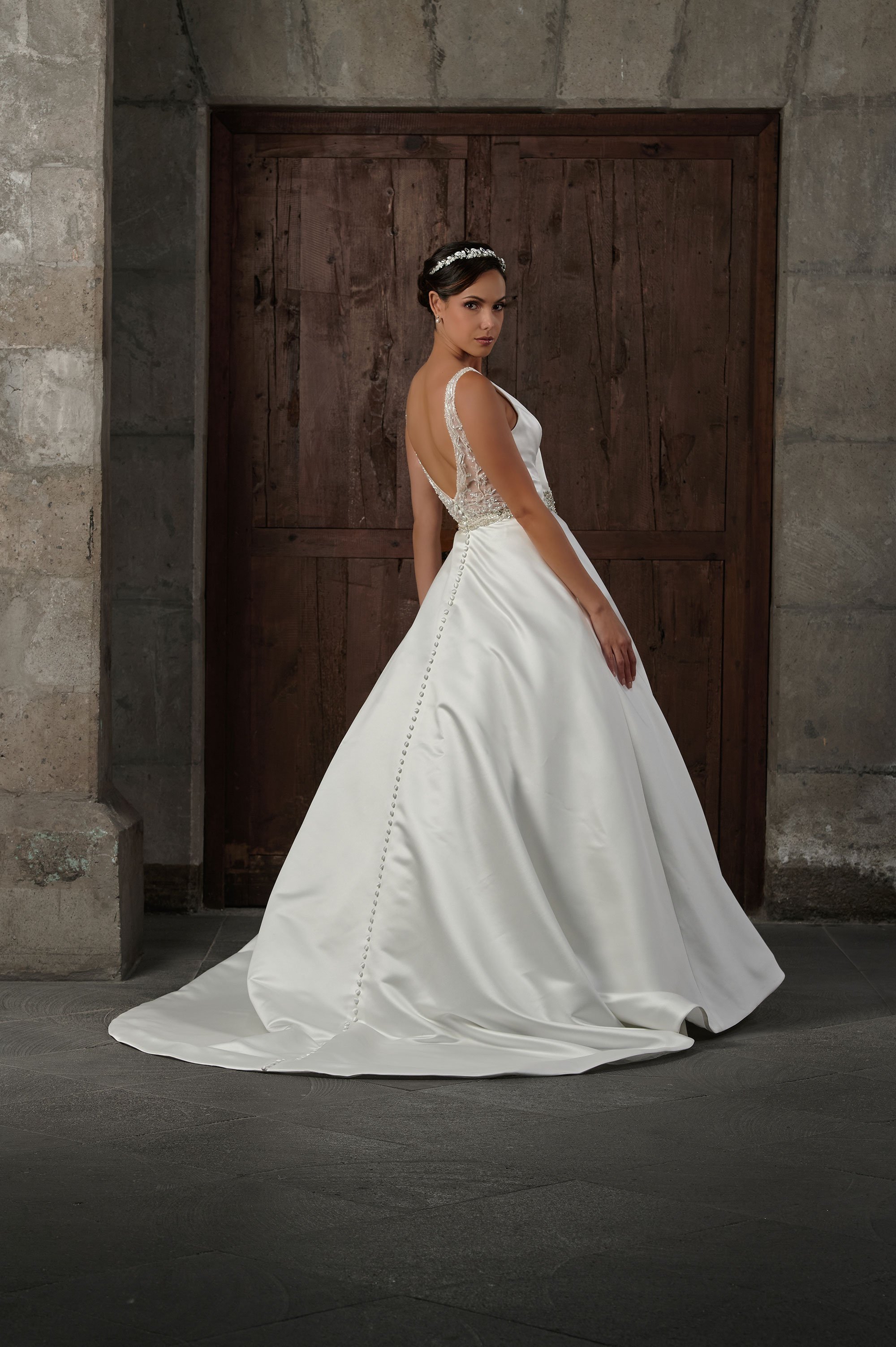 Espalda semitransparente del vestido de novia Qebi con botones forrados y cola larga.