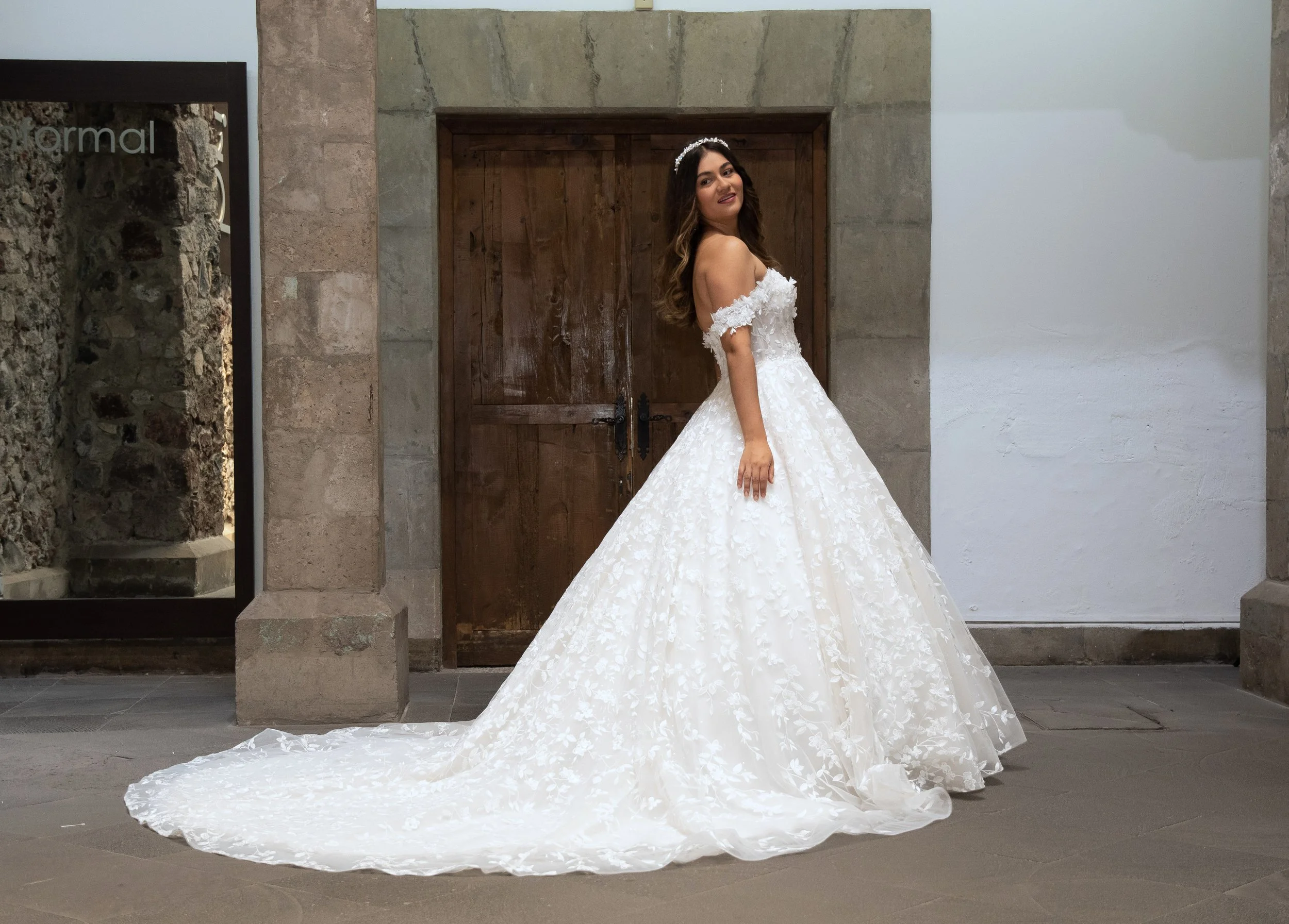 Vestido de novia Margot de frente con la falda floral voluminosa y la cola extendida.