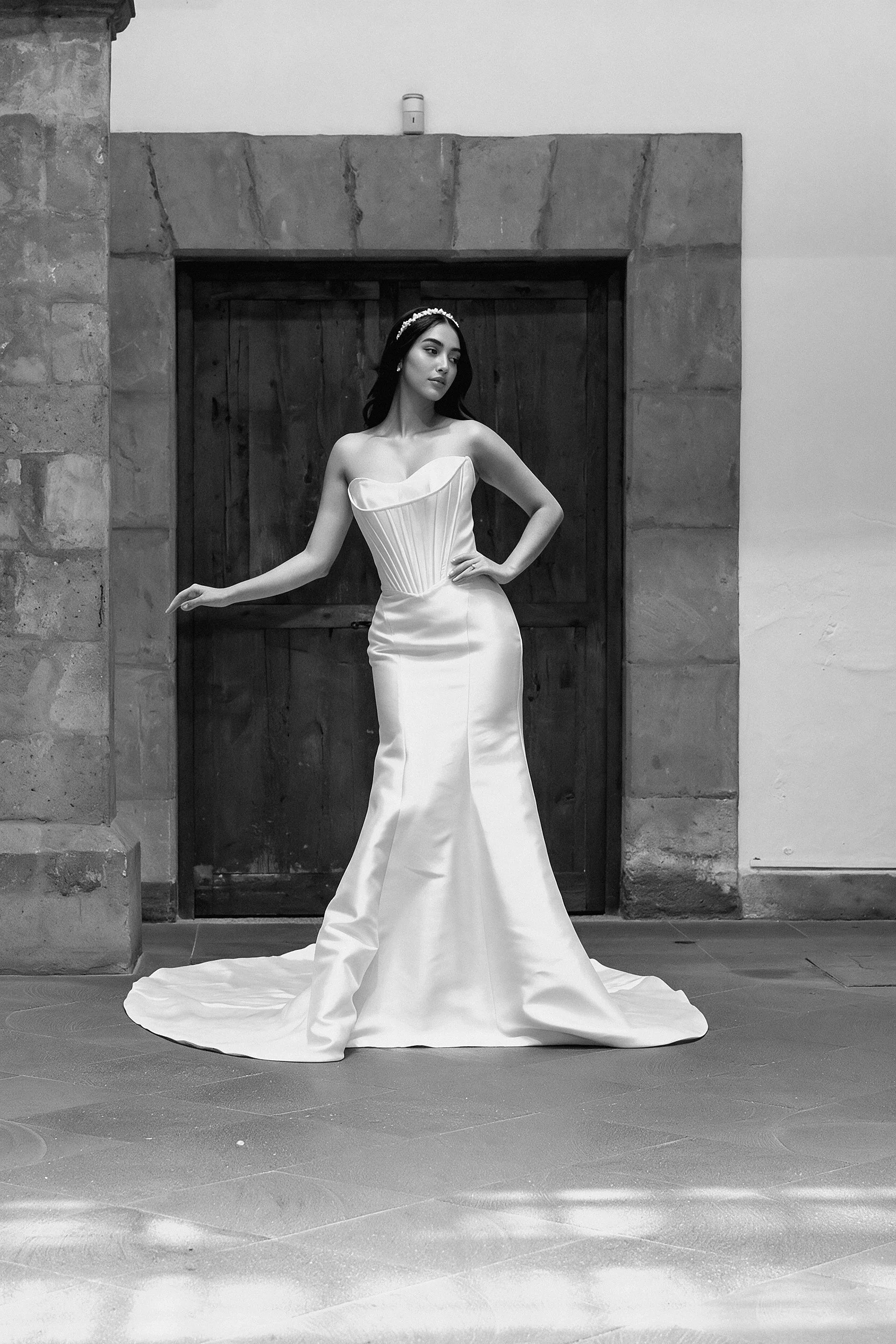 Novia con el vestido Love de Bridenformal, silueta entallada de satén con escote corazón, vista frontal completa.