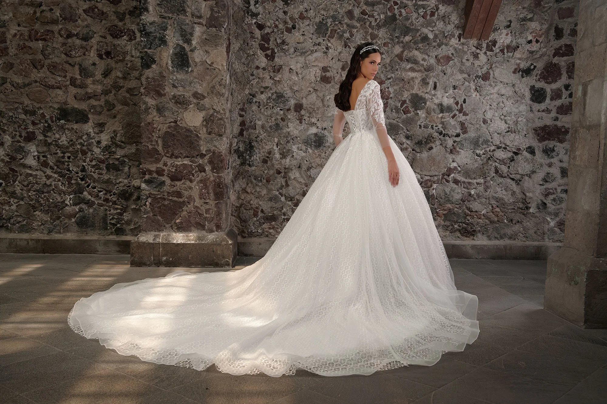 Espalda del vestido de novia Corina con falda de tul brillante y cola larga.