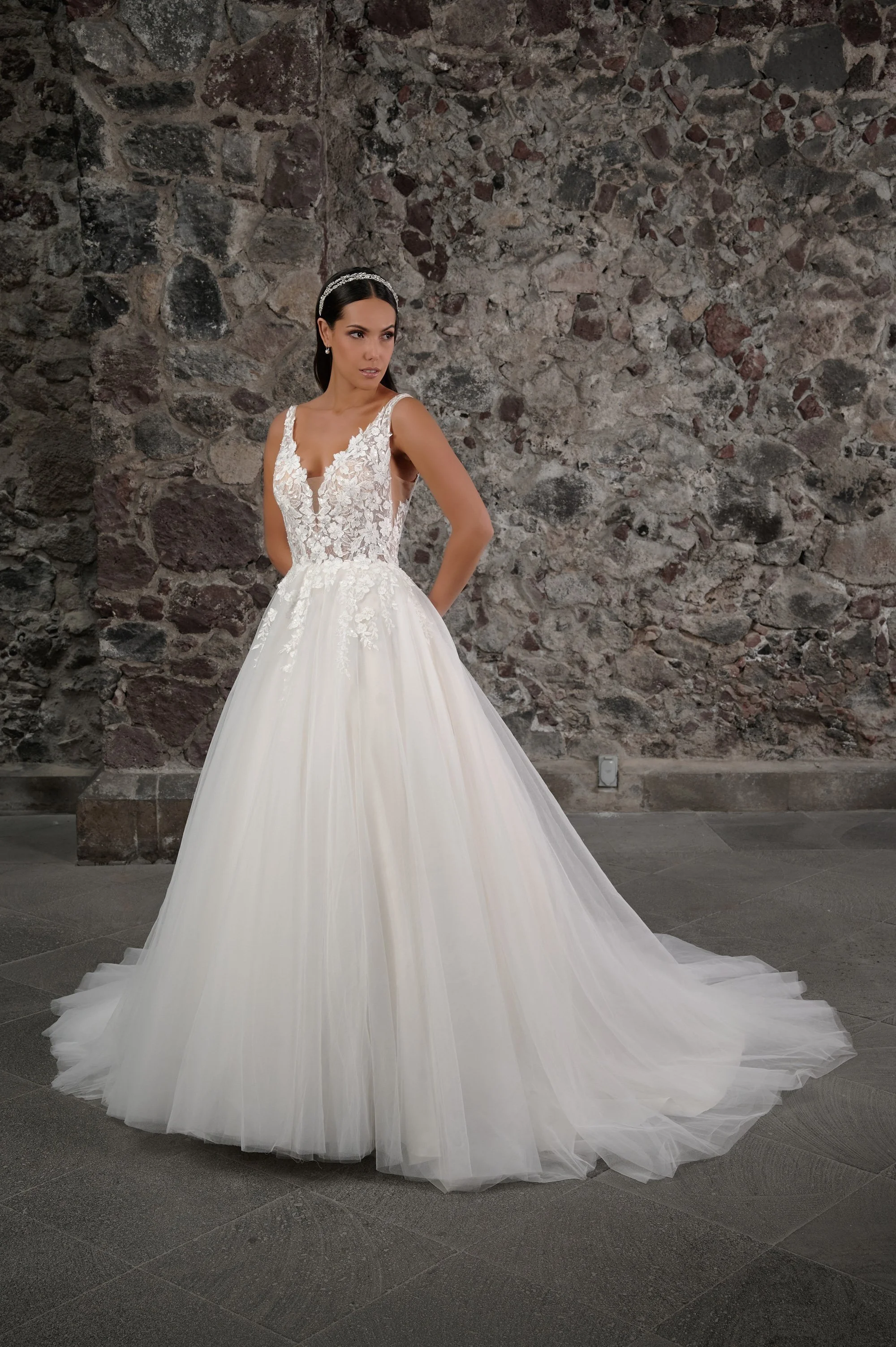 Novia con el vestido Clavel de Bridenformal, princesa de tul con encaje floral y escote en V, vista frontal con cola.