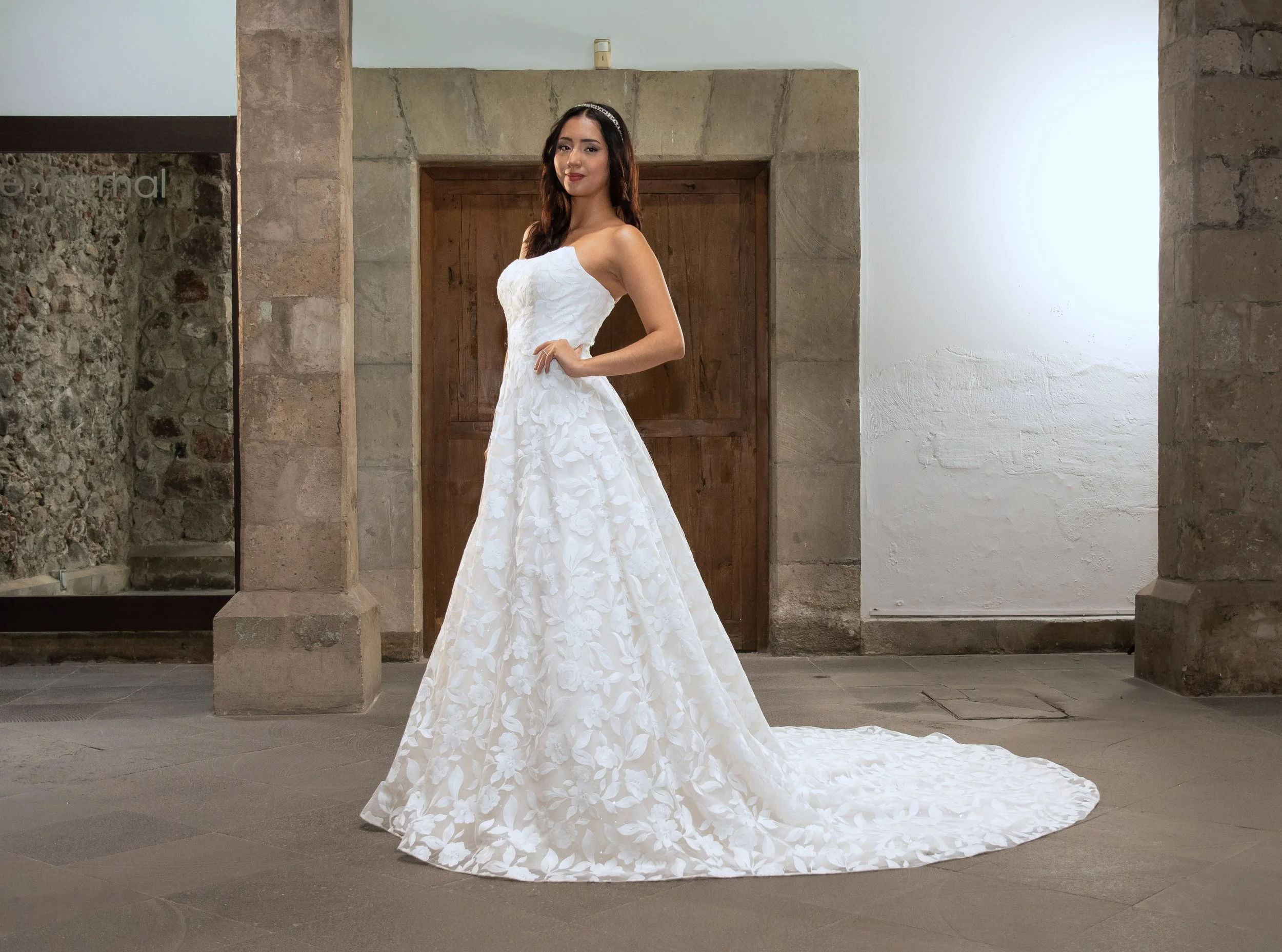 Novia con el vestido Look de Bridenformal, silueta línea A con escote corazón y falda de aplicaciones florales, vista frontal completa.