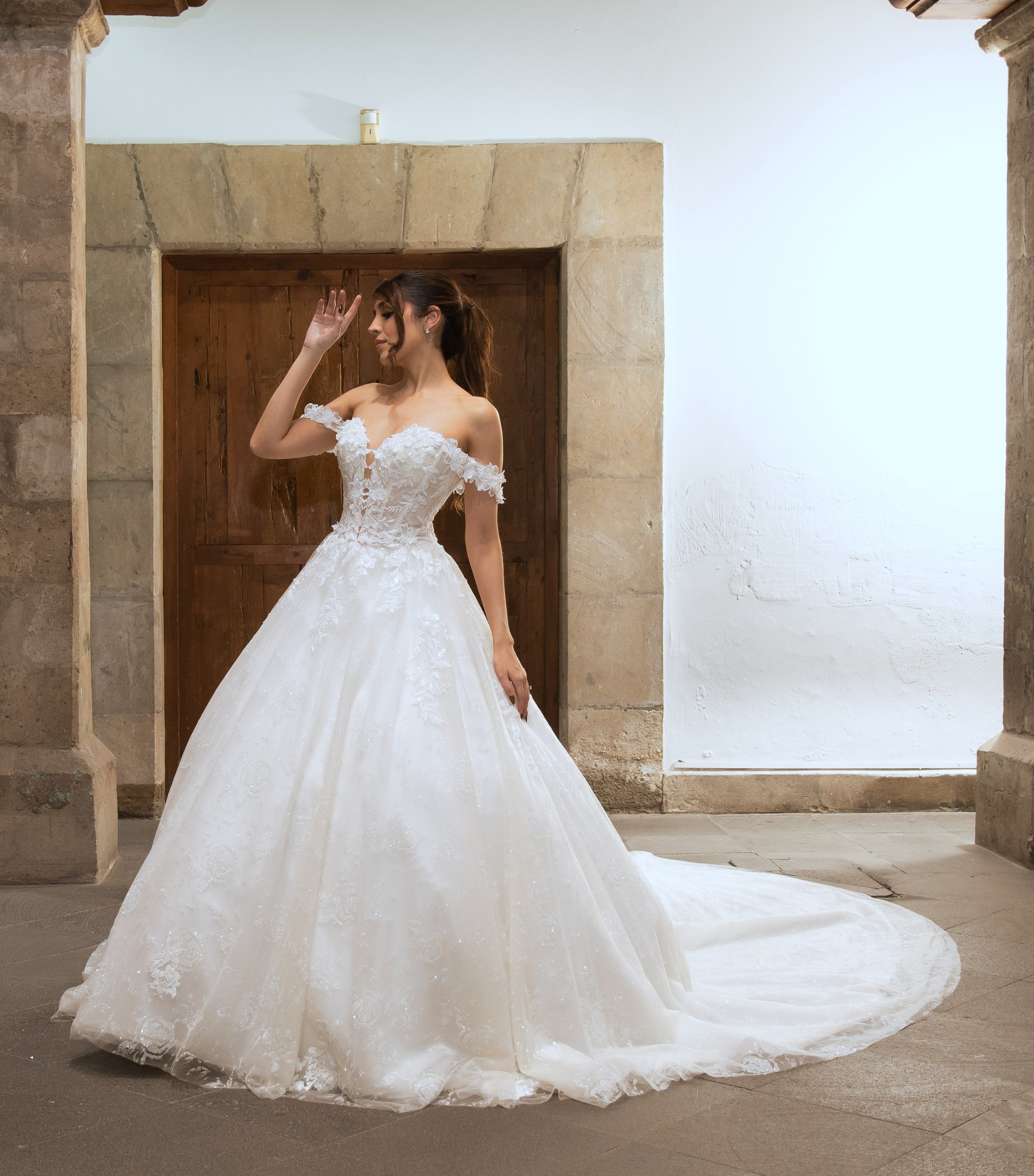 Novia con el vestido Marisol de Bridenformal, princesa de tul con flores en relieve y tirantes caídos, vista frontal completa.