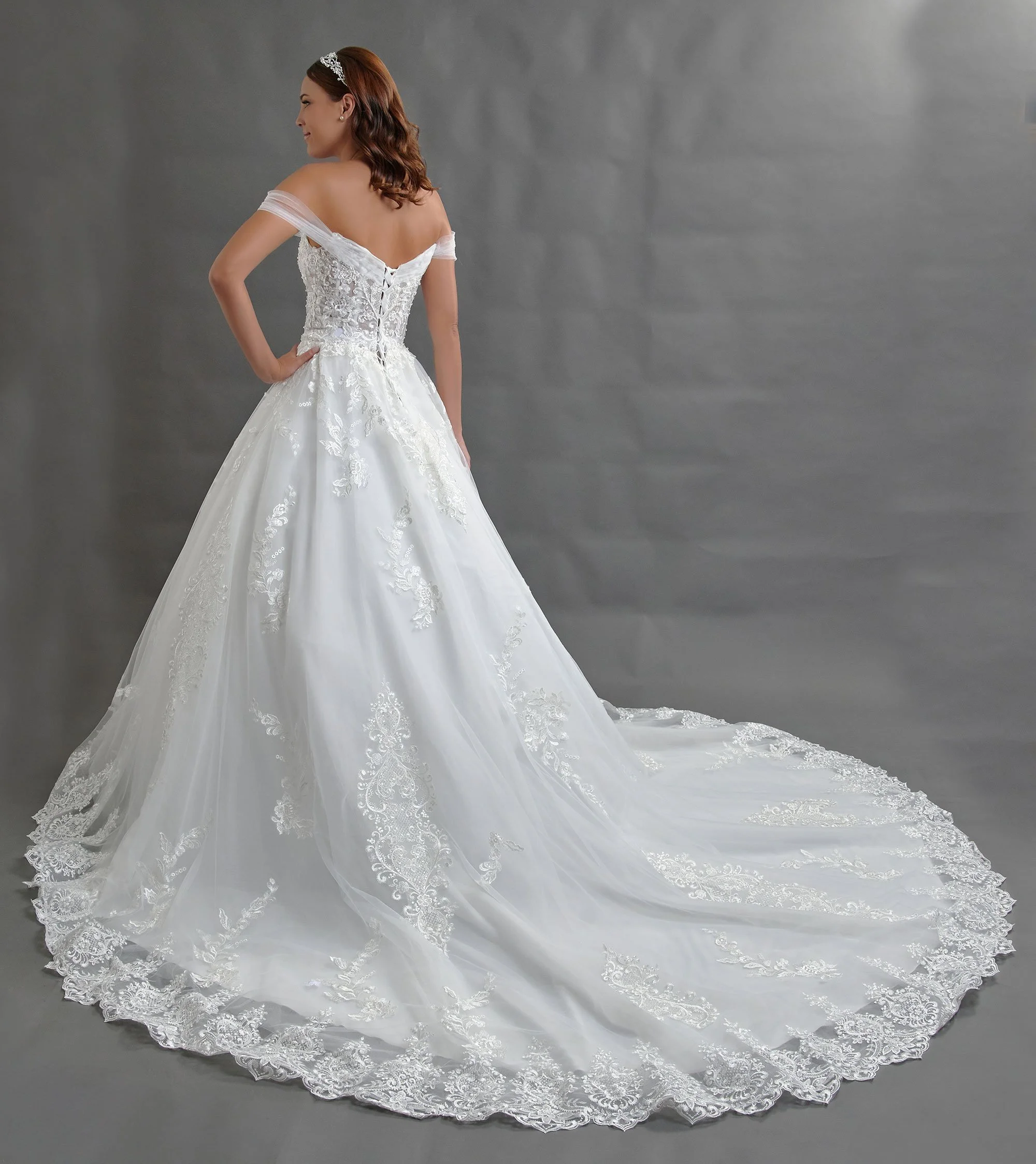 Espalda del vestido de novia Berna con corsé de amarre y falda de tul con cola larga.