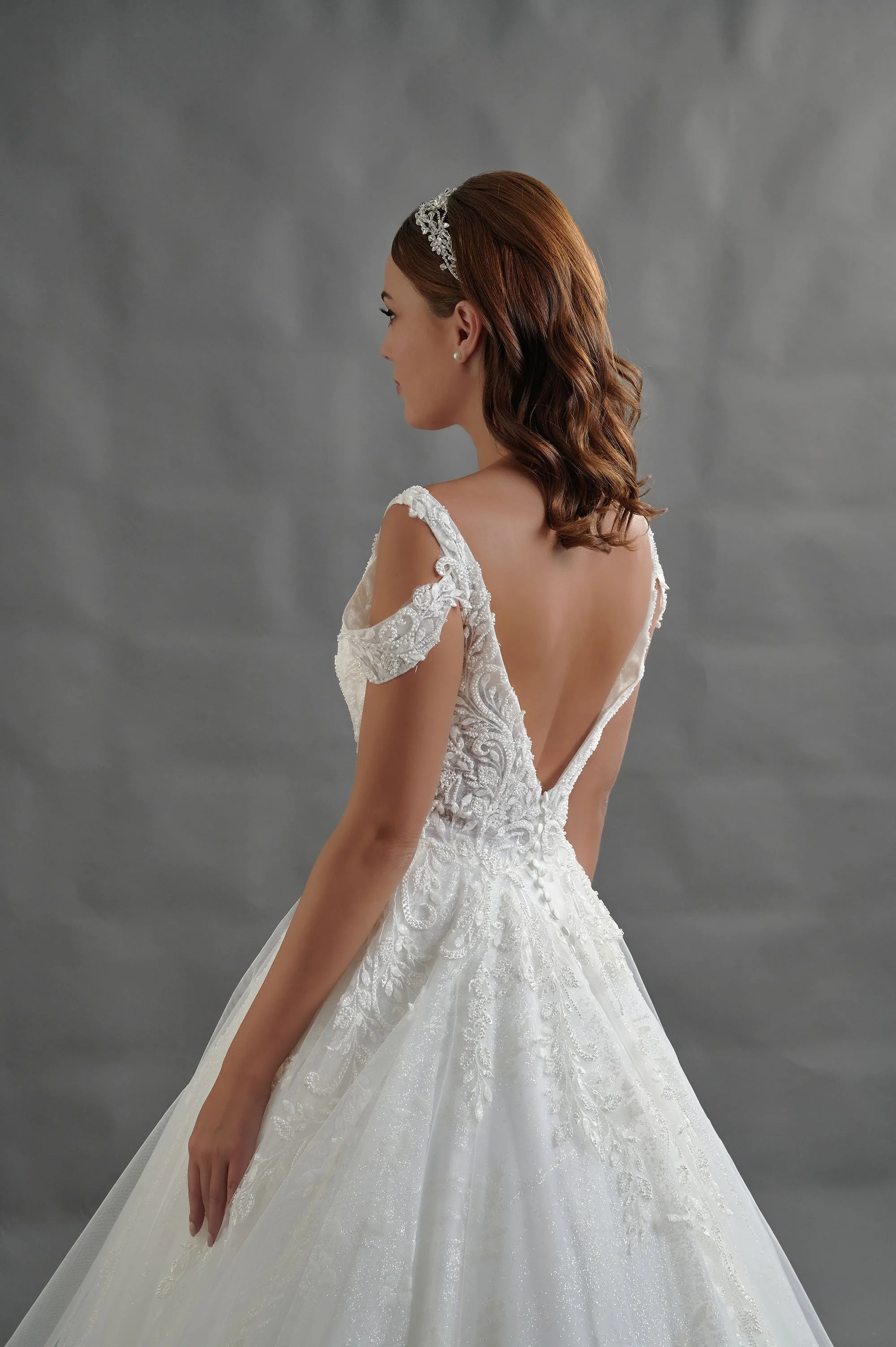 Detalle de la espalda en V del vestido de novia Berlange con mangas caídas de encaje.
