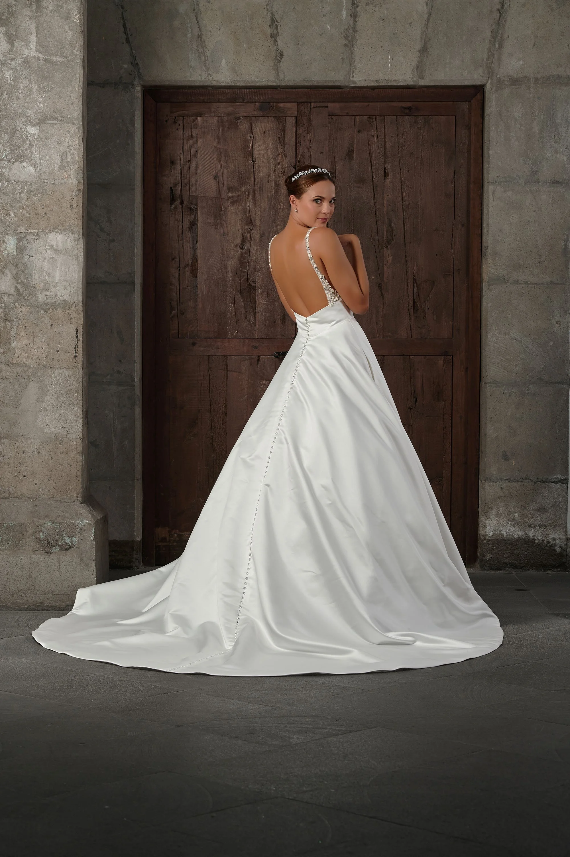 Espalda del vestido de novia Qamar con botones forrados y cola larga de satén.