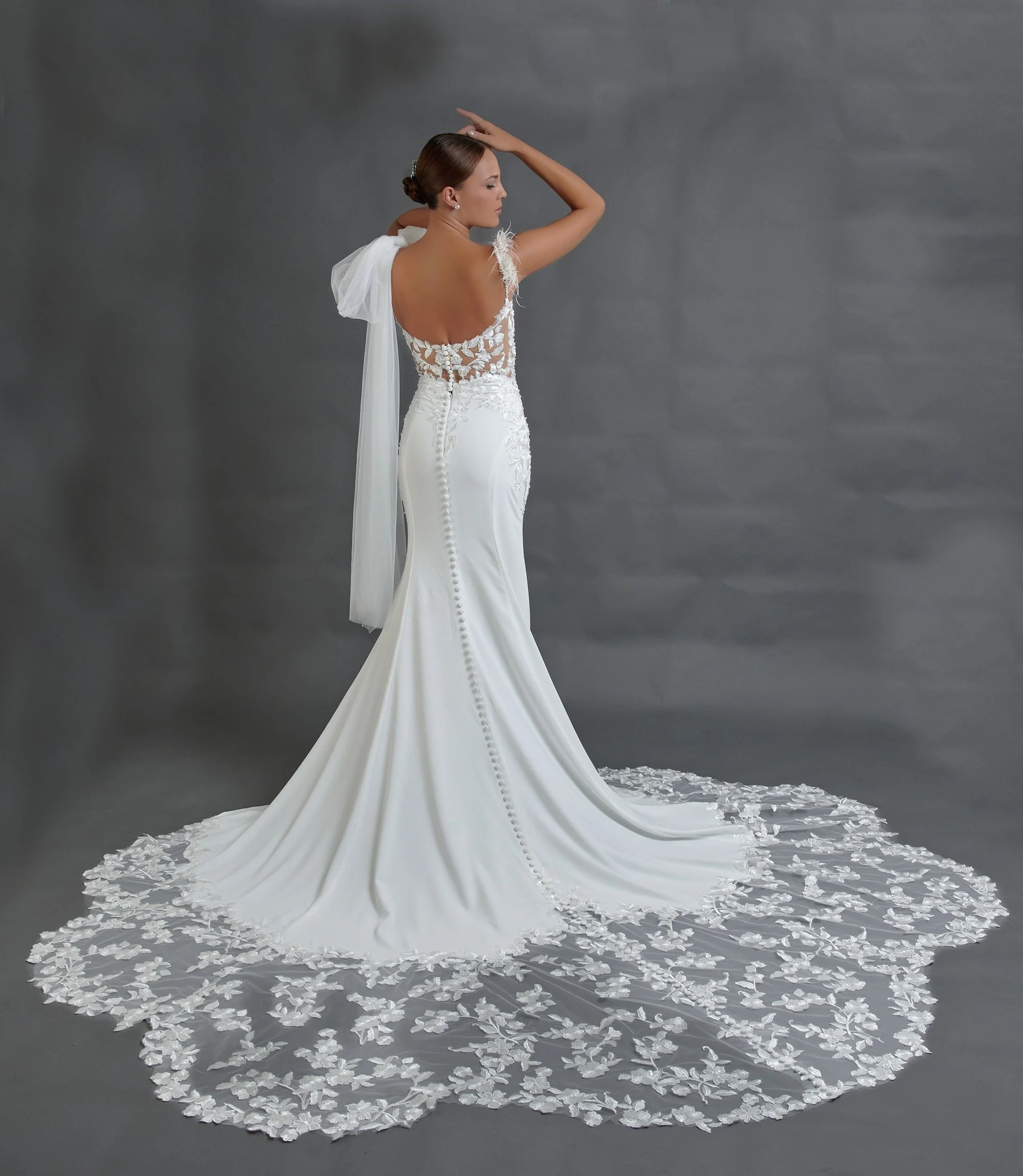 Espalda del vestido de novia Baran con cola larga y amplio borde de encaje floral festoneado.
