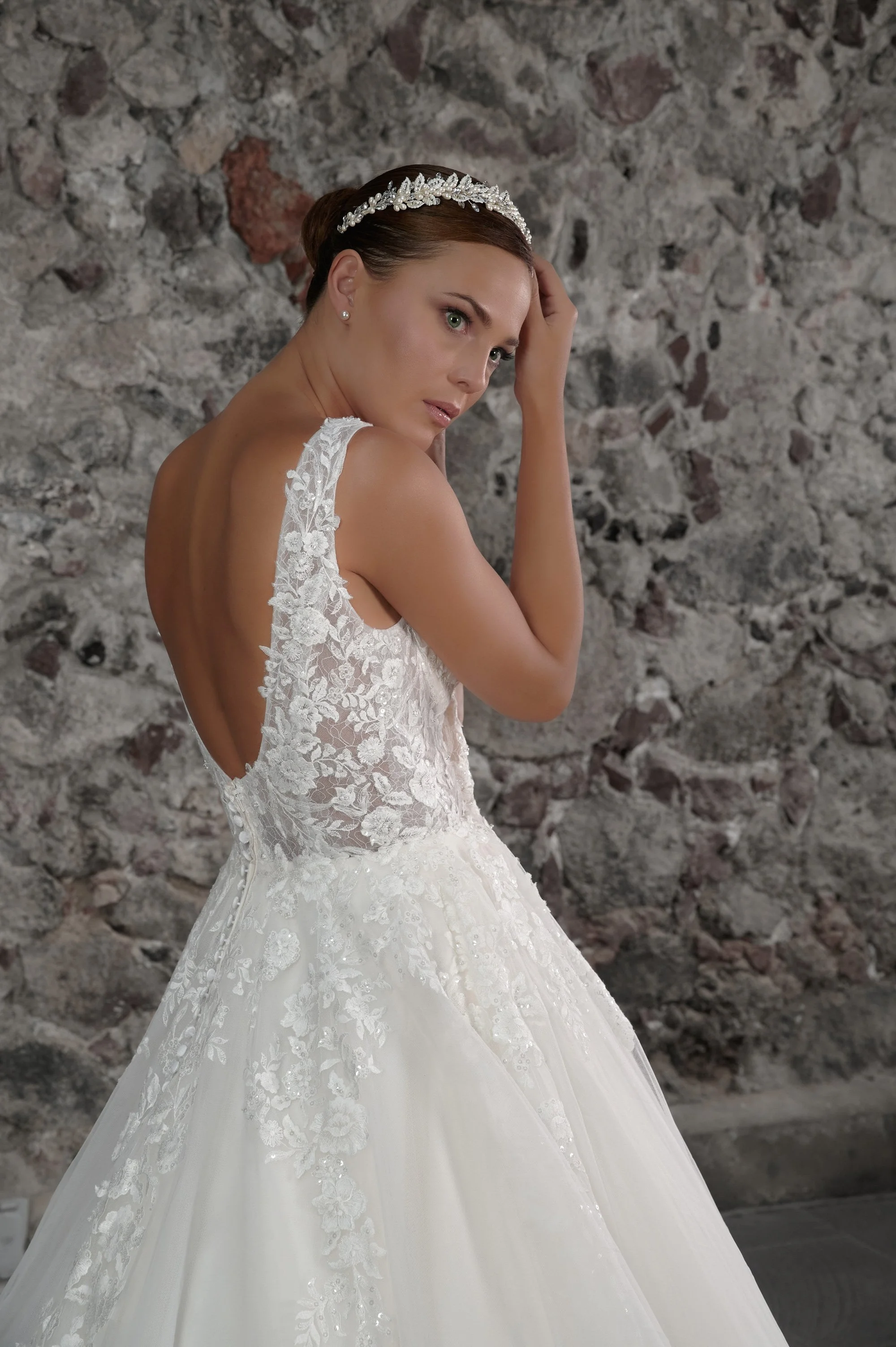 Novia con el vestido Clara de Bridenformal, princesa de tul con encaje floral y escote en V, vista frontal con cola.