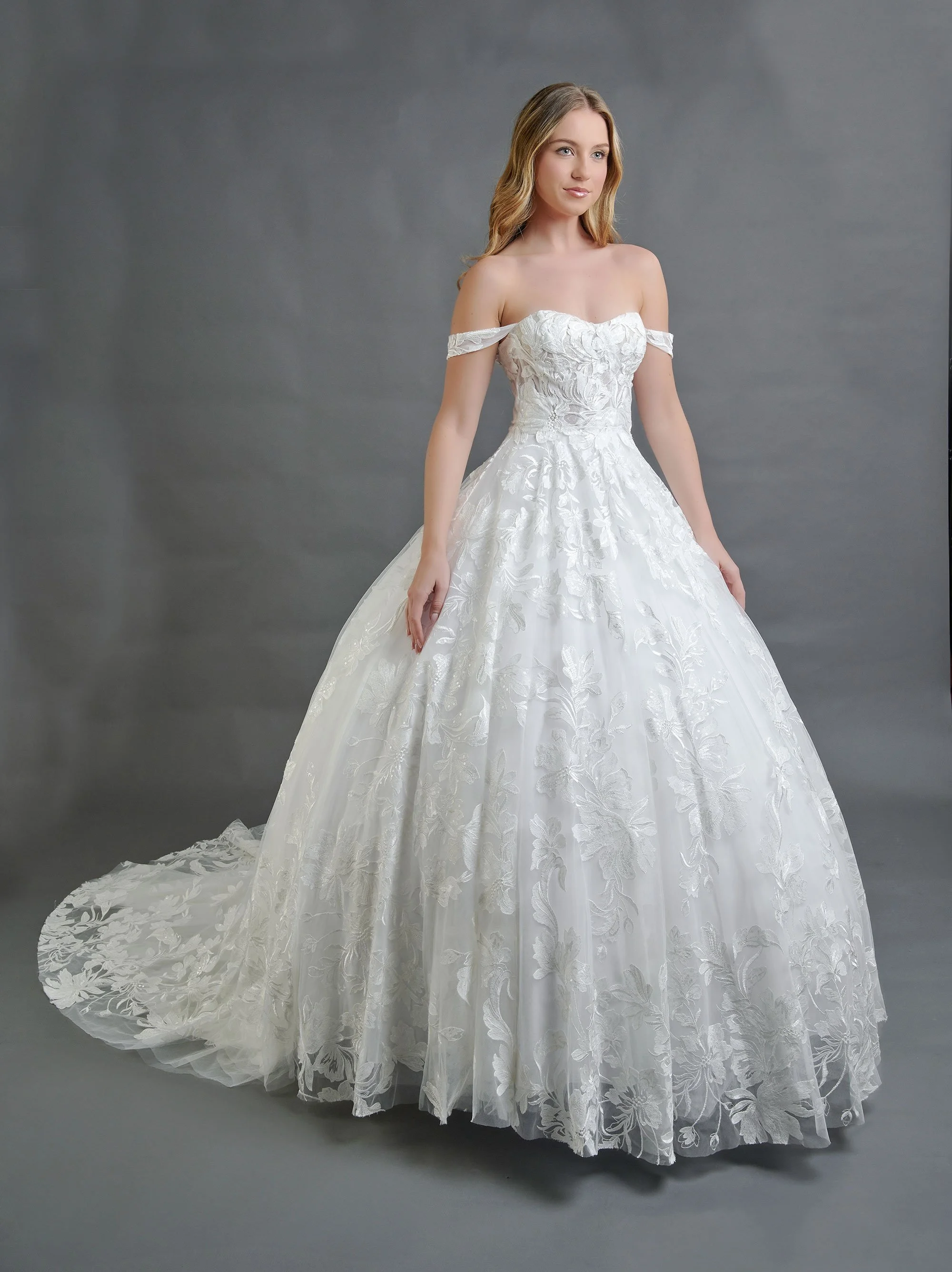 Novia con el vestido Barcelona de Bridenformal, princesa bordada en encaje floral con mangas caídas, vista frontal con cola.