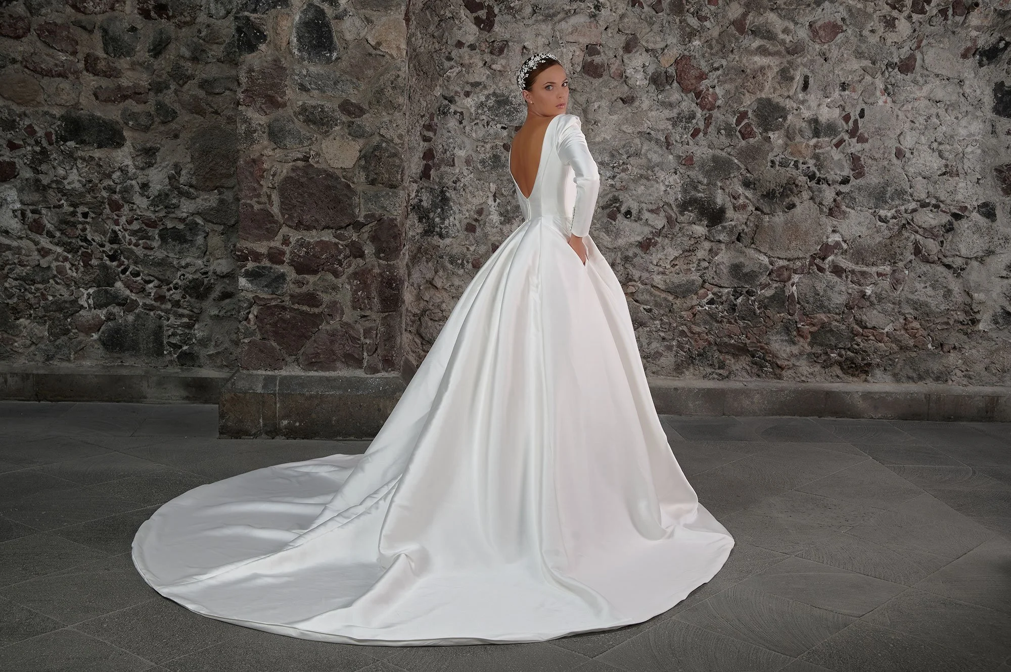 Espalda del vestido de novia Celeste con escote en V profundo, falda de satén y cola larga.