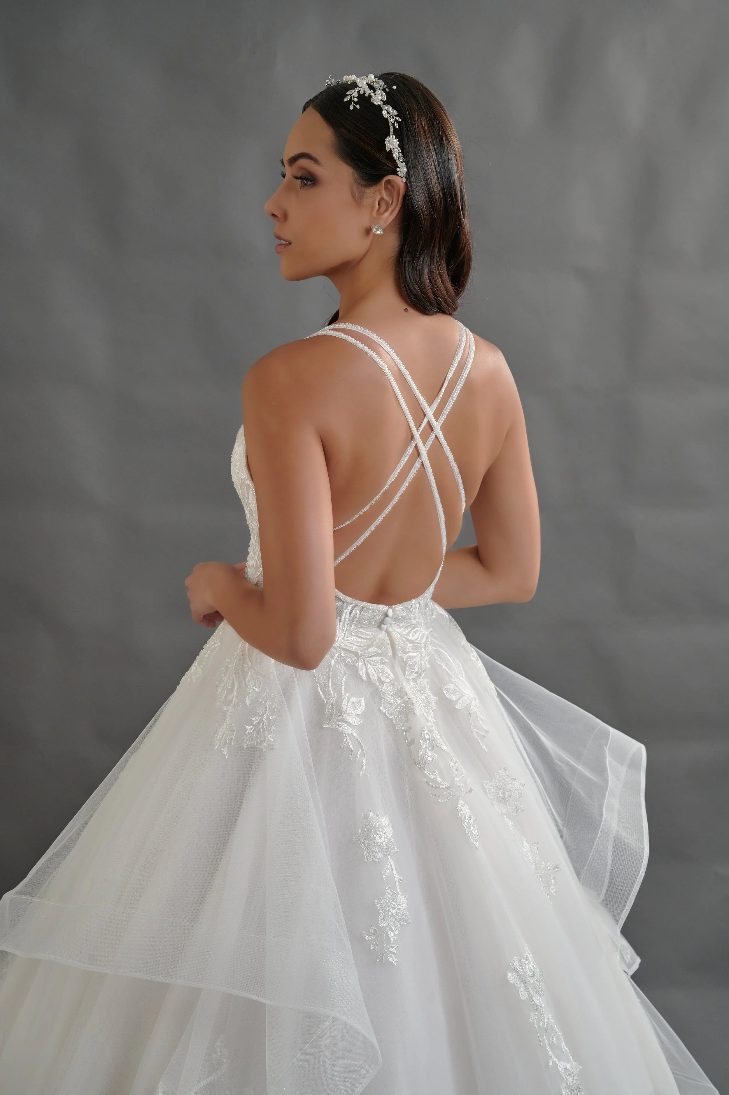 Detalle de la espalda descubierta del vestido Baiona con tirantes finos cruzados y pedrería.