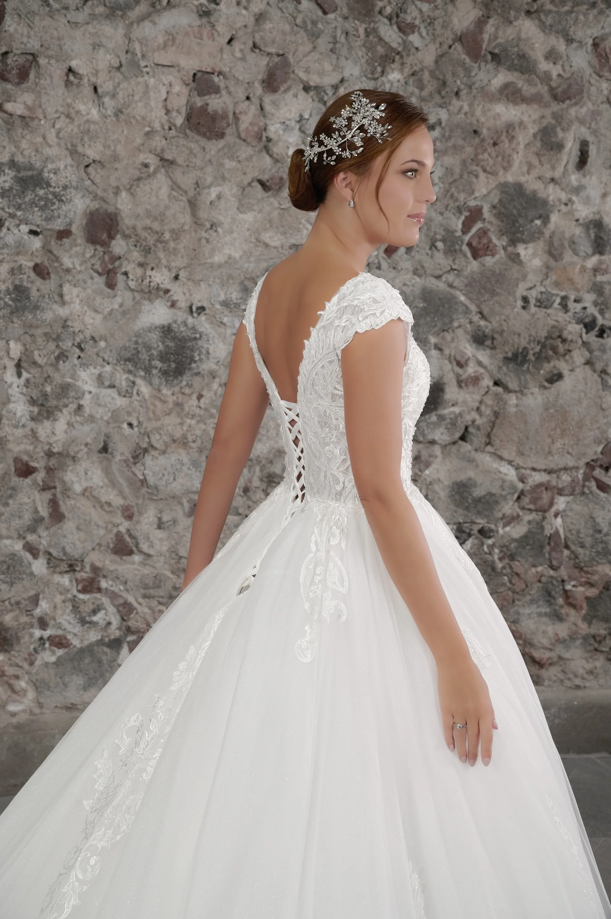 Detalle de la espalda en V del vestido Cristal con mangas cap de encaje y corsé de amarre.