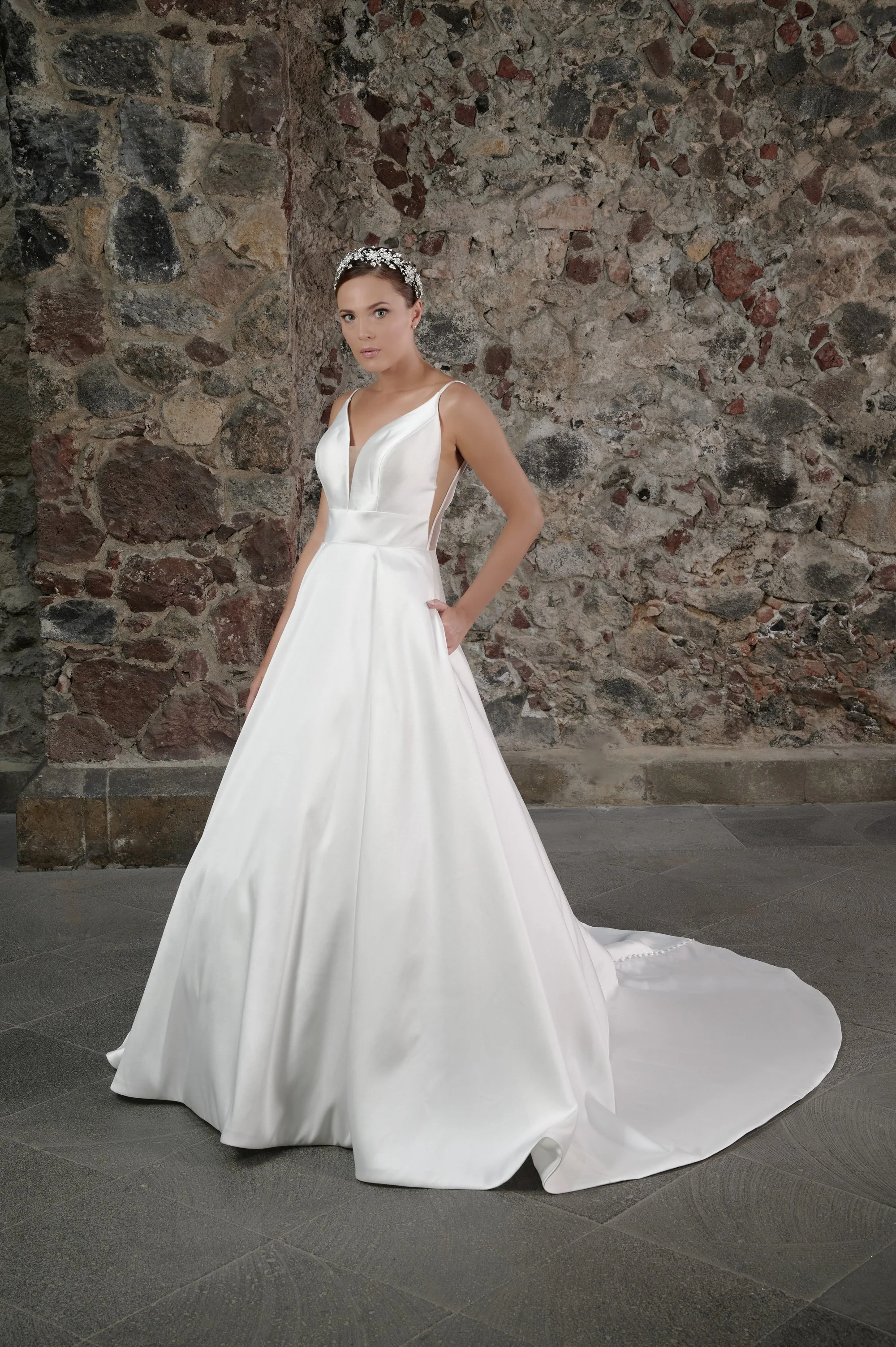 Novia con el vestido Celso de Bridenformal, princesa de satén liso con escote en V, vista frontal con cola.
