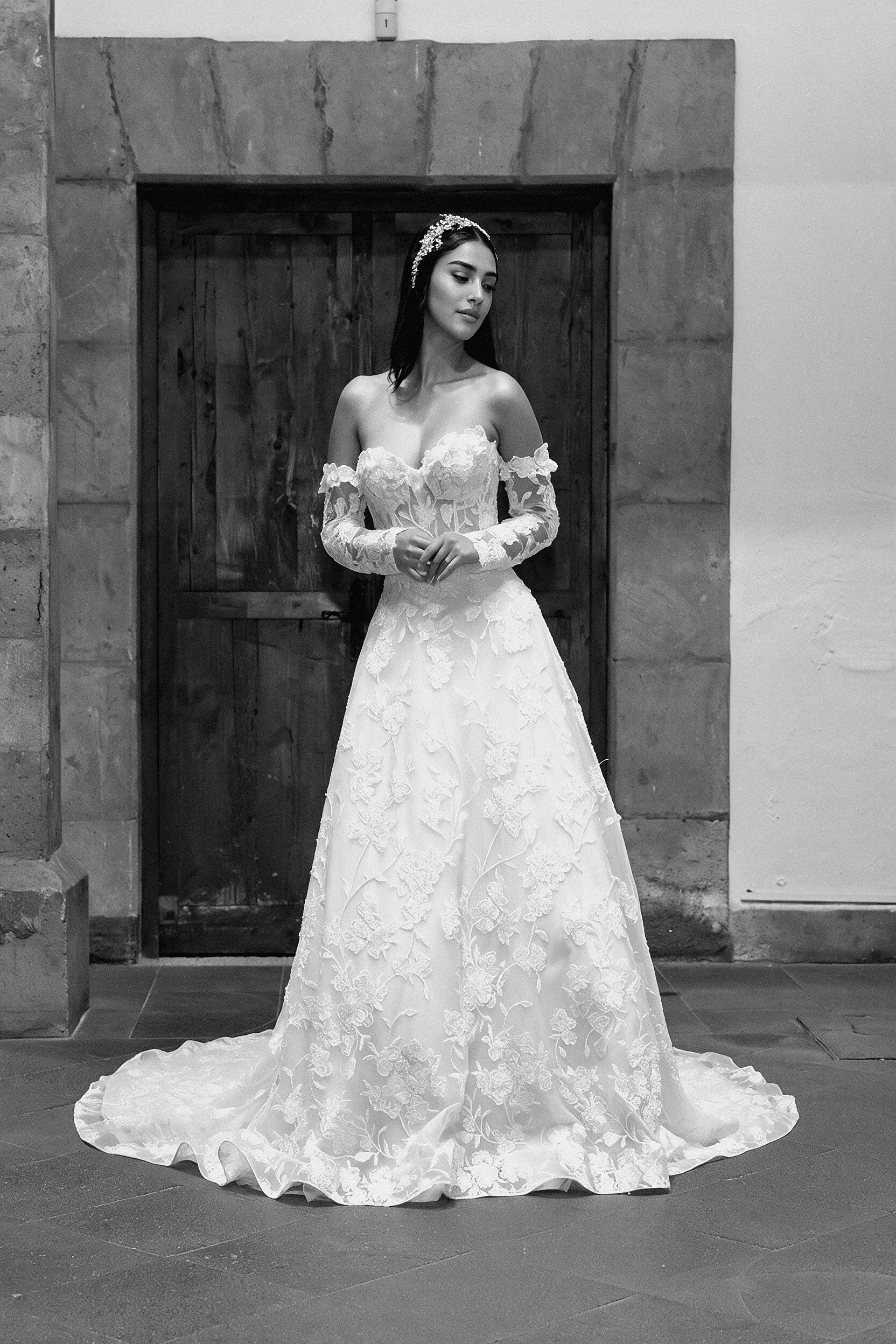 Novia con el vestido Lucas de Bridenformal, línea A de encaje con escote corazón y mangas largas desmontables, vista frontal completa.