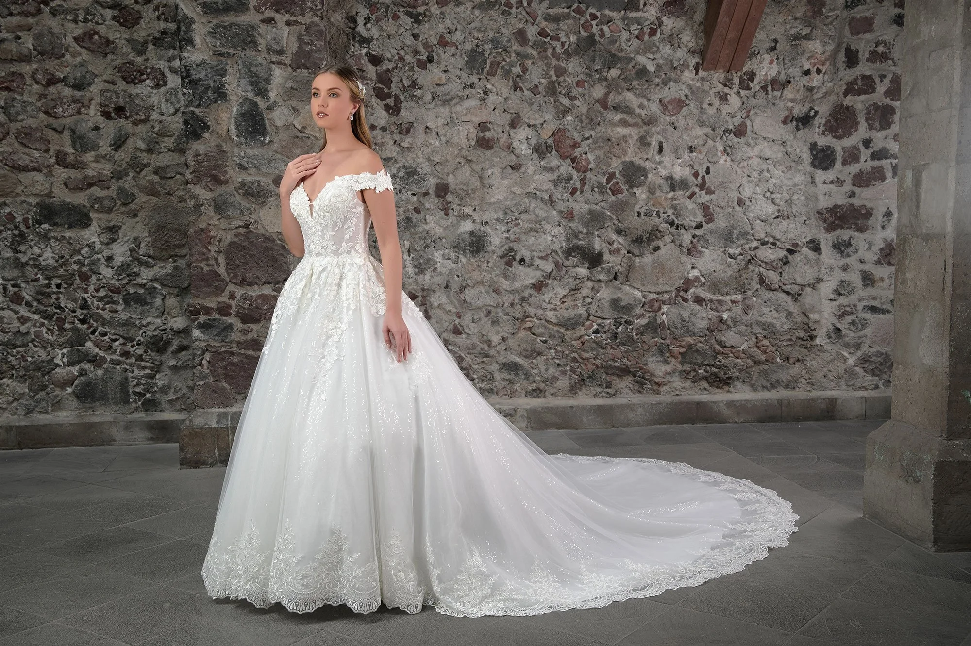 Novia con el vestido de novia Calaita, princesa de tul con brillo y encaje floral, vista frontal con cola.